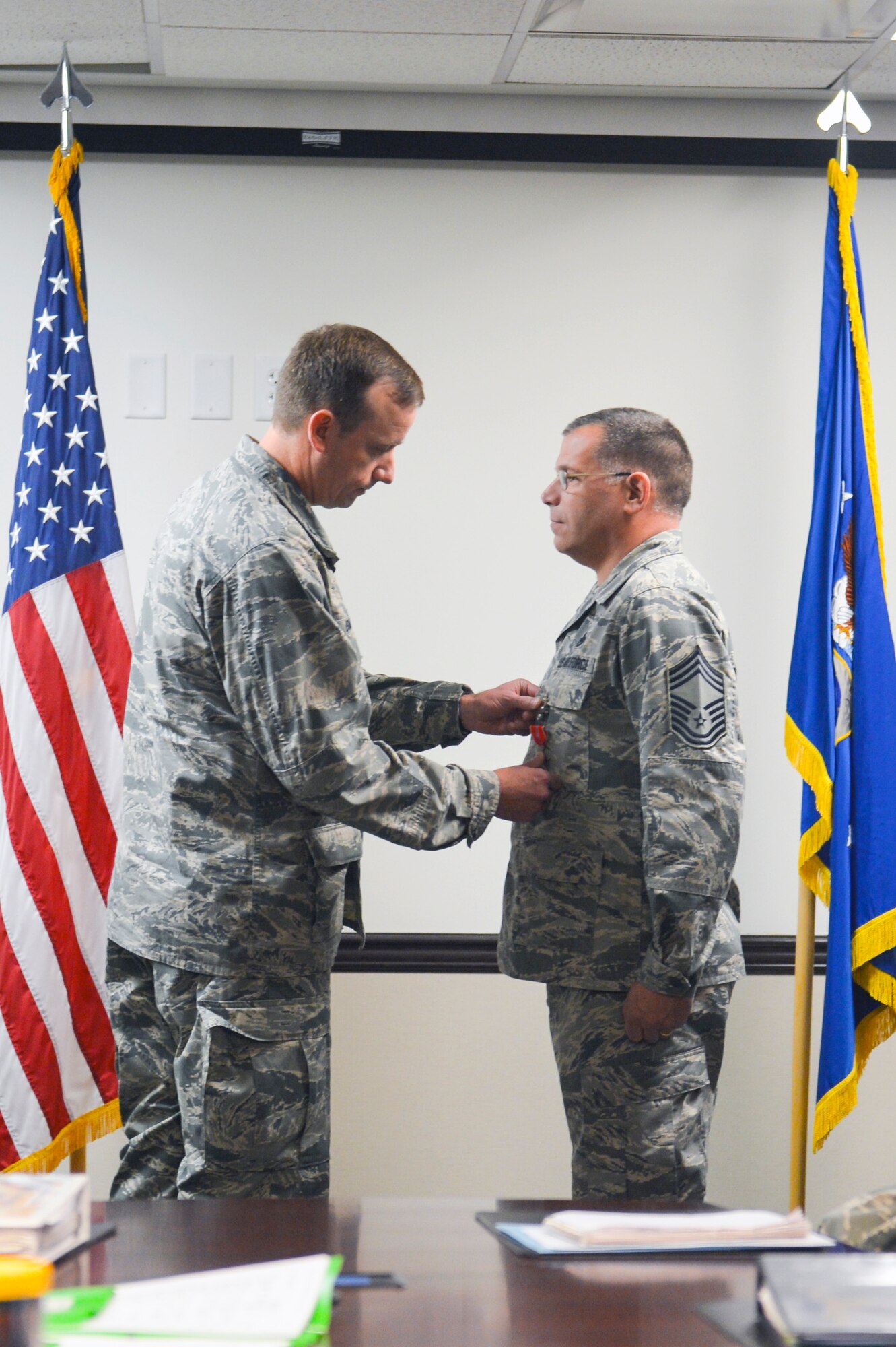 Col. Craig Gaddis (left), 62nd Maintenance Group commander, pins a Bronze Star medal onto Chief Master Sgt. John Frazier (right), 62nd MXG superintendent, during an award ceremony Dec. 3, 2014, at Joint Base Lewis-McChord, Wash. The Bronze Star was awarded to Frazier, who had distinguished himself by meritorious service in connection with military operations against an armed enemy. (U.S. Air Force photo/Staff Sgt. Russ Jackson)