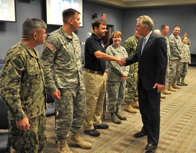 Terry McAuliffe, Virginia governor, is greeted by Brooks Holder, Joint Task Force Civil Support director of financial management, during a tour at Fort Eustis, Va., Dec. 2, 2014. The JTF-CS anticipates, plans and prepares for chemical, biological, radiological and nuclear response operations. (Official Department of Defense photo by Navy Petty Officer 1st Class Brian Dietrick/Released)