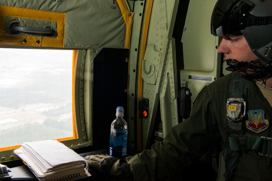 U.S. Air Force Senior Airman Jeremy Burgess, 71st Rescue Squadron loadmaster, looks out of a window during a static-line jump Nov. 13, 2014, while flying over Moody Air Force Base, Ga. Rescue loadmasters assist pilots in searching for missing personnel and equipment and conducting cargo and personnel airdrops. (U.S. Air Force photo by Airman 1st Class Ryan Callaghan)