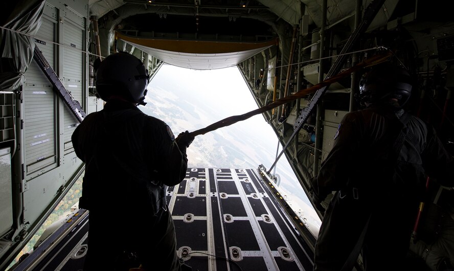 U.S. Air Force Senior Airmen Jeremy Burgess, left, and Christopher Alvey, 71st Rescue Squadron loadmasters, hold a static-line after a static-line jump Nov. 13, 2014, while flying over Moody Air Force Base, Ga. Loadmasters are responsible for calculating aircraft weight, balance records and cargo manifest, conducting cargo and personnel airdrops, and troubleshooting in-flight problems. (U.S. Air Force photo by Airman 1st Class Ryan Callaghan)