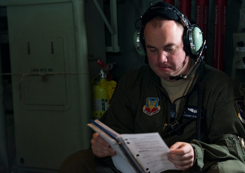 U.S. Air Force Senior Airman Christopher Alvey, 71st Rescue Squadron loadmaster, reads a checklist before a static-line jump Nov. 13, 2014, while flying over Moody Air Force Base, Ga. The checklist is used to assist in pre-flight, in-flight, airdrops, and air refueling capabilities. (U.S. Air Force photo by Airman 1st Class Ryan Callaghan)