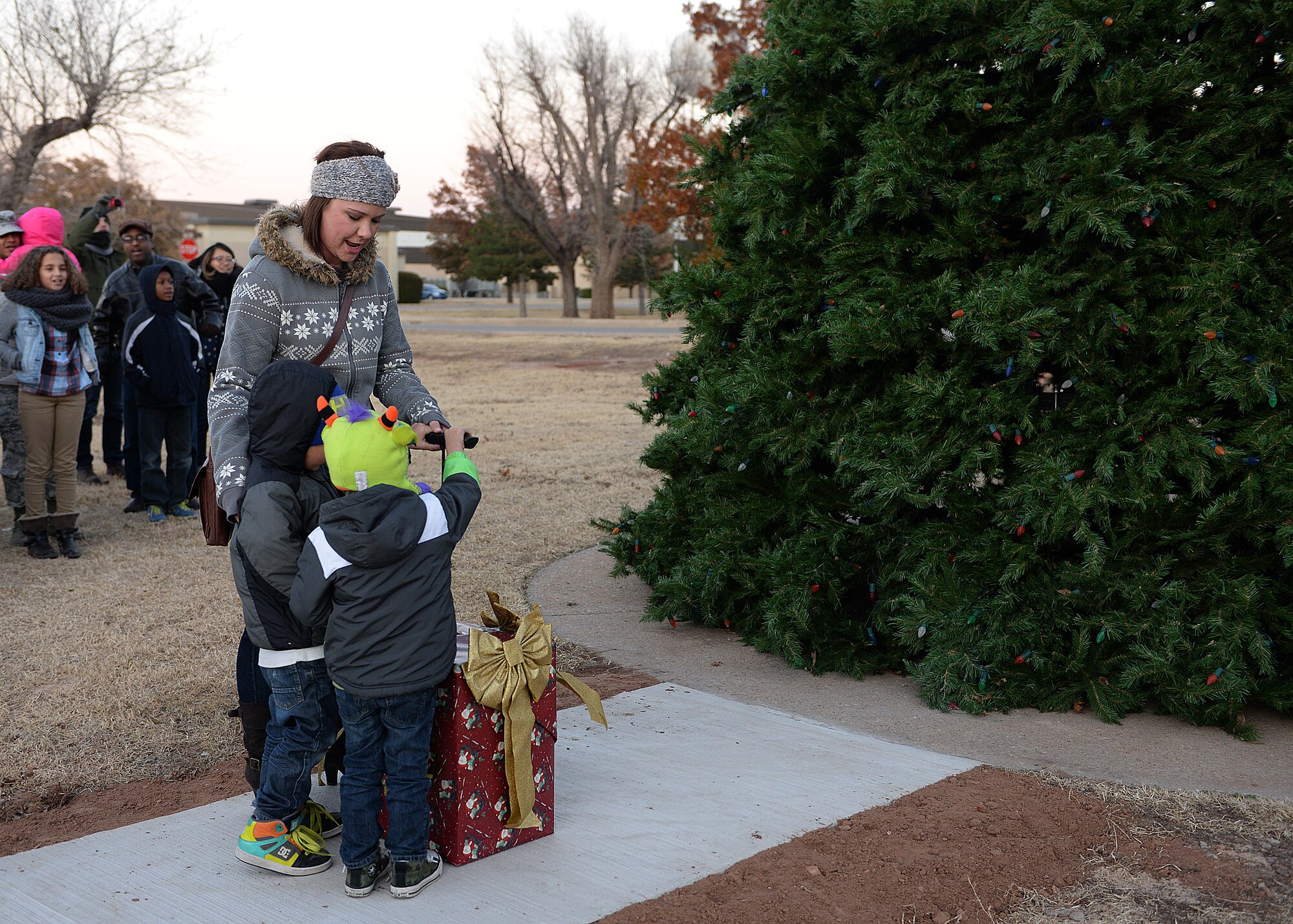 ALTUS AIR FORCE BASE, Okla. – The family of a deployed Altus Airman lights the Christmas tree at the tree lighting ceremony at Wings of Freedom Park, Dec. 1, 2014. In the past, the tree was lit by base leadership, but the past few years the honors have been given to families of Airmen who are deployed during the holidays.  (U.S. Air Force photo by Airman 1st Class Megan Acs/Released)