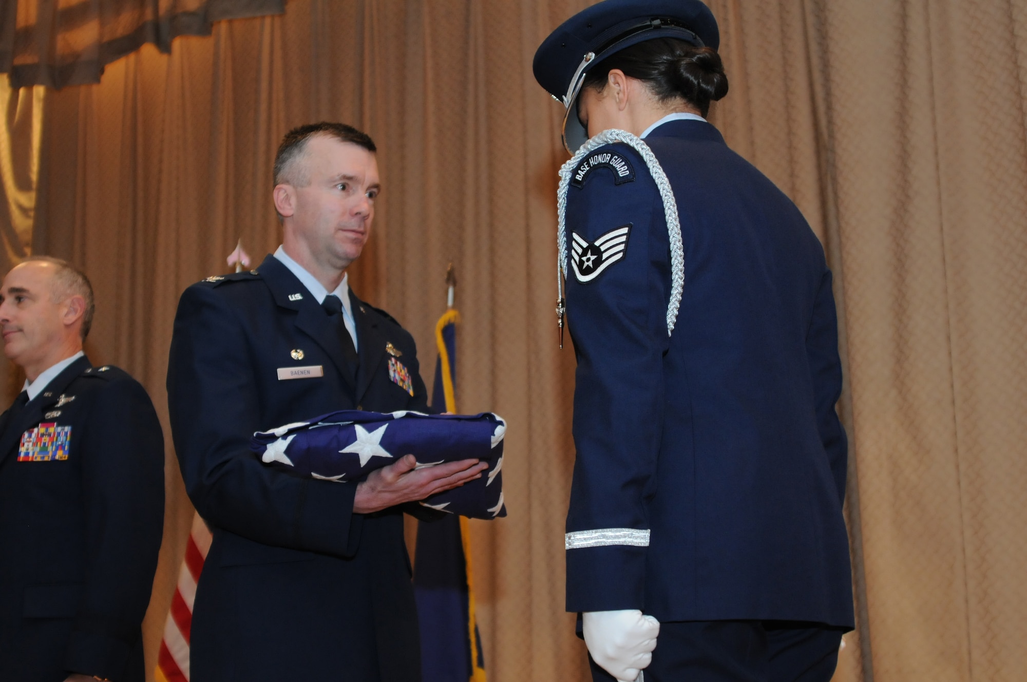 Col. Jeremy “Weed” Baenen accepts a flag in honor of his 26 years of service to the United States Air Force and the Oregon Air National Guard during his retirement ceremony, Nov. 21, 2014 at Kingsley Field in Klamath Falls, Ore. The day marked his last as the 173rd Fighter Wing Commander. (U.S. Air National Guard photo by Tech. Sgt. Jefferson Thompson/Released)