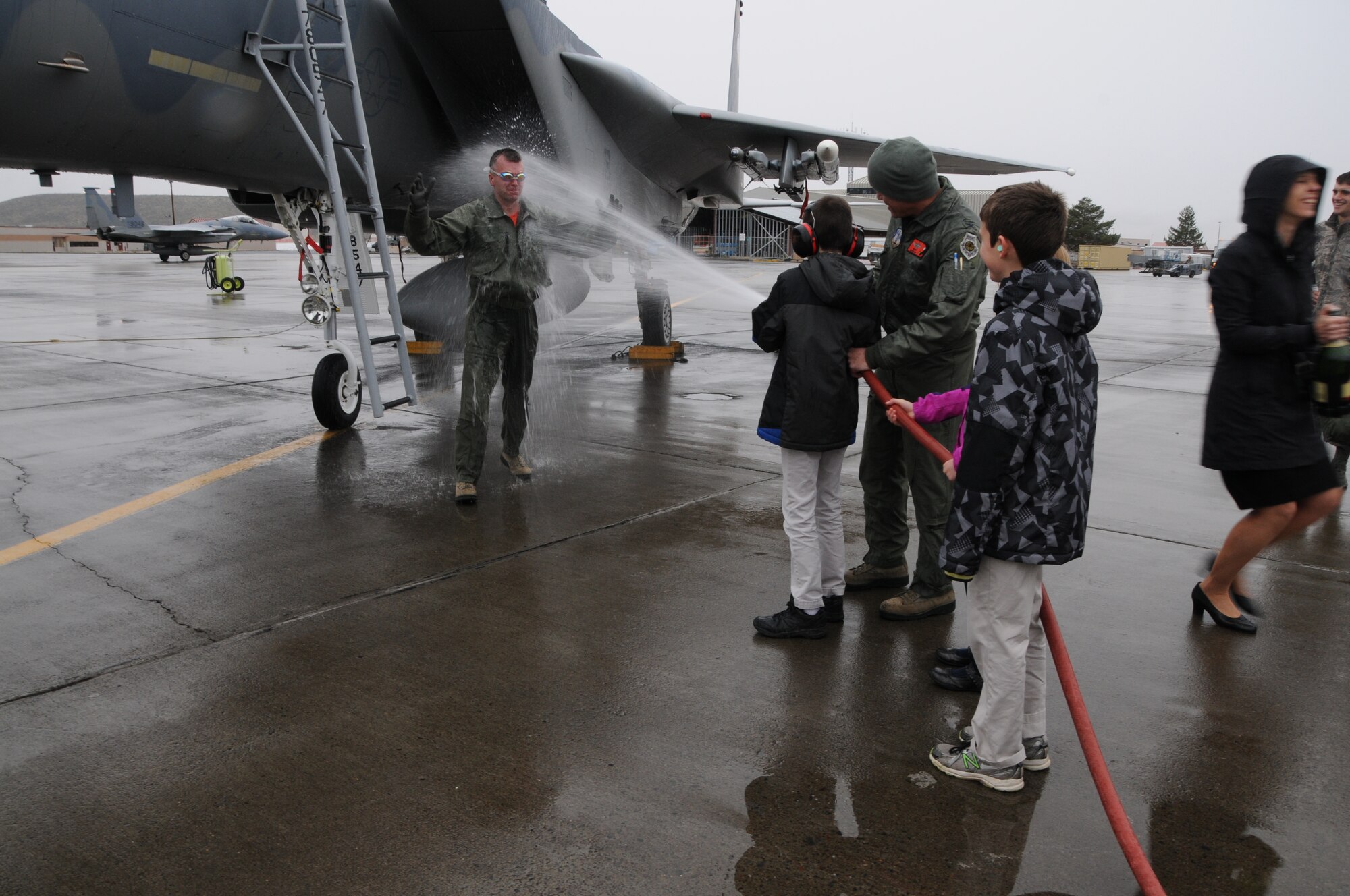 Col. Jeremy “Weed” Baenen welcomes a cold blast of water upon stepping to the tarmac following his last flight in the F-15 Eagle shortly before his retirement ceremony, Nov. 21, 2014. The dousing is part of the traditional fini flight for pilots upon their last flight in an aircraft. (U.S. Air National Guard photo by Tech. Sgt. Jefferson Thompson/Released)