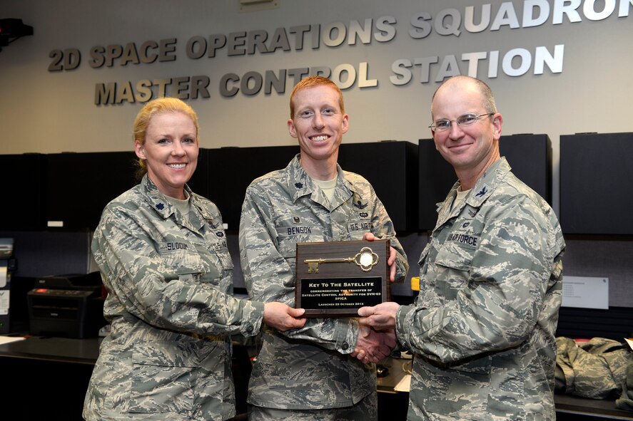 Col. Dennis Bythewood (right), 50th Operations Group commander, presents a ceremonial key for the eighth GPS Block IIF satellite (SVN-69) to Lt. Col. Todd Benson, 2nd Space Operations Squadron commander and Lt. Col. Karen Slocum, 19th Space Operations Squadron director of operations, Nov. 25, 2014, at Schriever Air Force Base, Colorado. The satellite launched from Cape Canaveral, Florida Oct. 29, 2014. Members of 2 and 19 SOPS conducted testing and evaluation of the vehicle prior to the satellite control authority transfer. Active-duty Airmen with 2 SOPS and Air Force Reservists with 19 SOPS command and control the 39-vehicle GPS constellation, which provides position, navigation and timing to billions of users around the world. (U.S. Air Force photo/Christopher DeWitt)