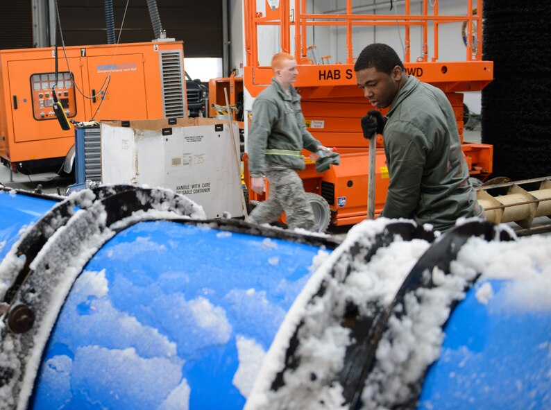 Airman 1st Class Pascal Dieujuste, 786th Civil Engineer Squadron Heavy Equipment Operator, cleans off a plow after the shop cleared the first snow of the season from the flightline Dec. 3, 2014, at Ramstein Air Base, Germany.  Dieujuste and a team of Airmen started early in the morning to ensure Ramstein can keep launching aircraft. (U.S. Air Force photo/Senior Airman Armando A. Schwier-Morales)