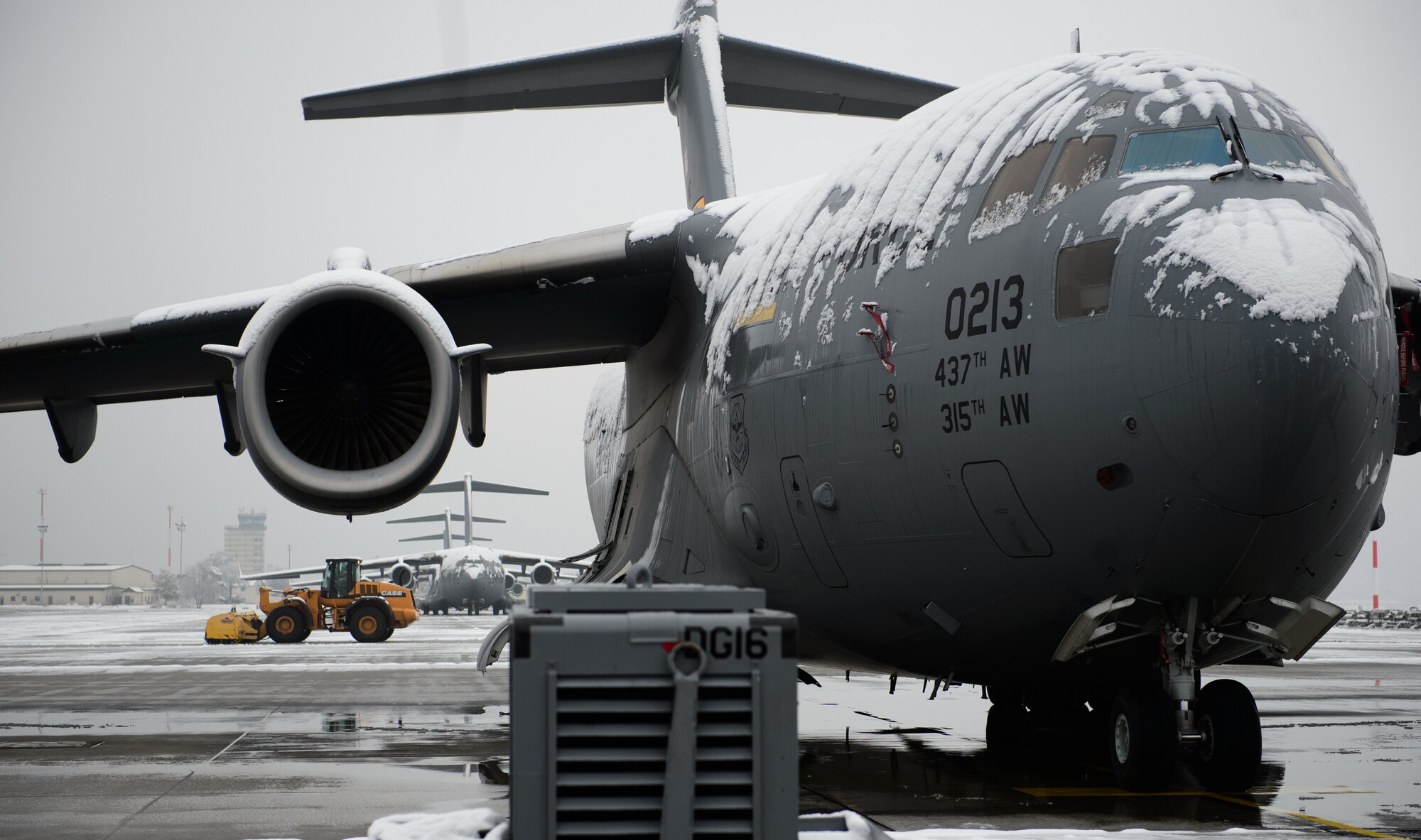 A C-17 Globemaster III sits on the Ramstein flightline after the first snowfall of the season as civil engineers clear the ramp Dec. 3, 2014, at Ramstein Air Base, Germany. The 786th Civil Engineer Squadron heavy equipment shop came in early in the morning to ensure Ramstein can keep launching aircraft. (U.S. Air Force photo/Senior Airman Armando A. Schwier-Morales)