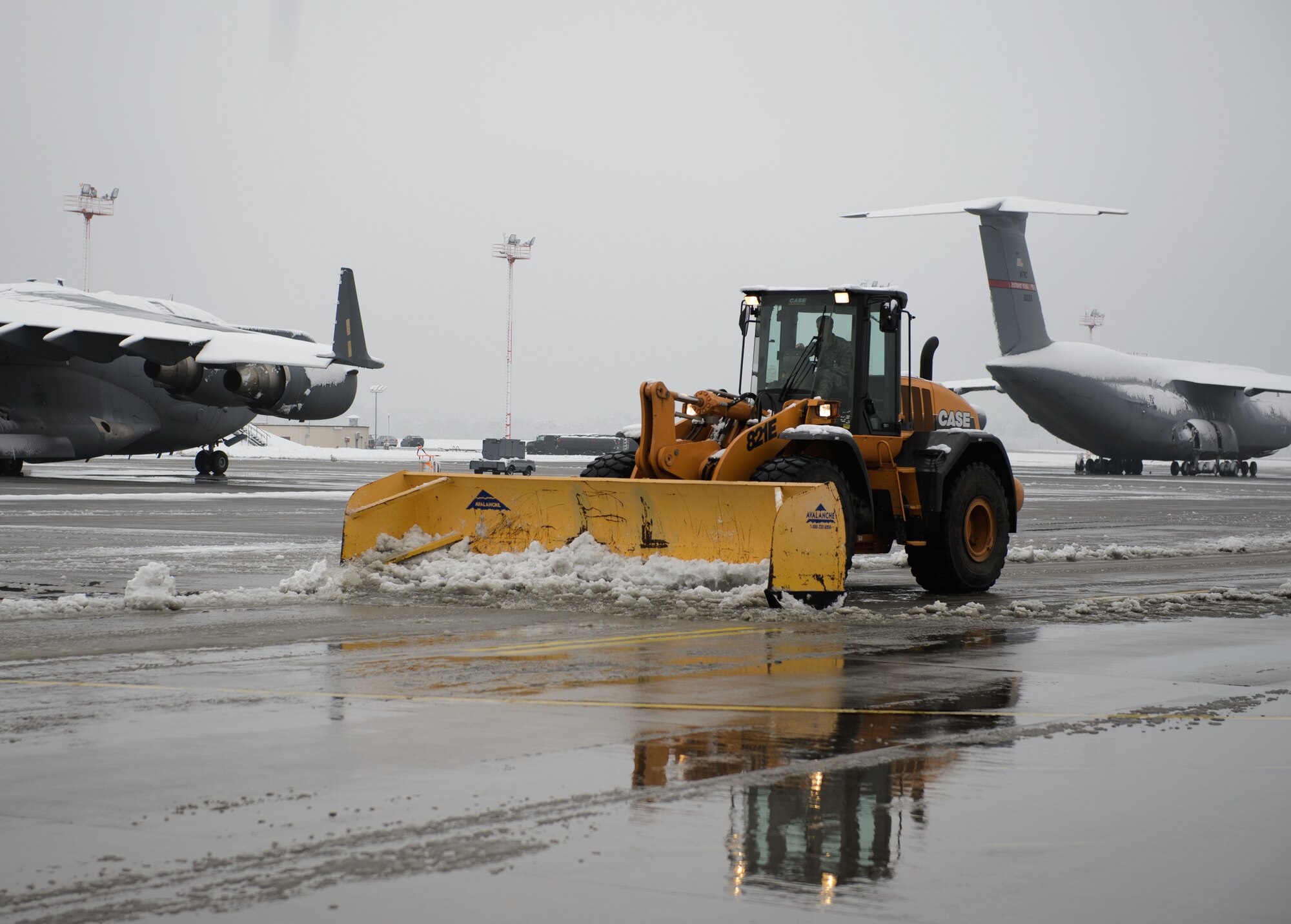 Airmen from the 786th Civil Engineer Squadron plow the remaining snow off the flightline after receiving the first snow of the season Dec. 3, 2014, at Ramstein Air Base, Germany. The 786th CES heavy equipment operators plow,  brush and keep the runways, taxiways and ramps clear to ensure mission success no matter the weather. (U.S. Air Force photo/Senior Airman Armando A. Schwier-Morales)