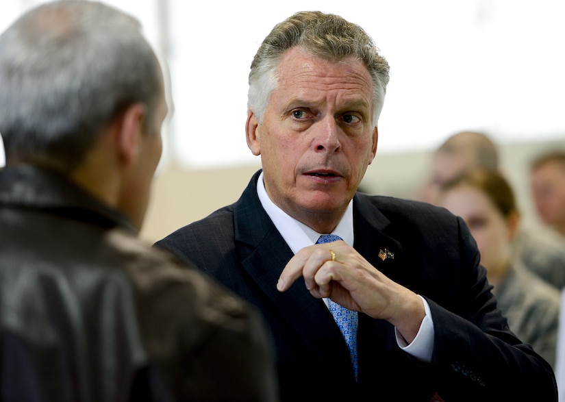Virginia Gov. Terry McAuliffe speaks with U.S. Air Force Col. Robert J. Grey, 192nd Fighter Wing commander, during a visit to Langley Air Force Base, Va., Dec. 2, 2014. While at Langley, McAuliffe spoke with Airmen from the 192nd FW, 633rd Mission Support Group, 633rd Medical Group and the 480th Intelligence Surveillance and Reconnaissance Wing about their missions. (U.S. Air Force photo by Senior Airman Kayla Newman/Released)