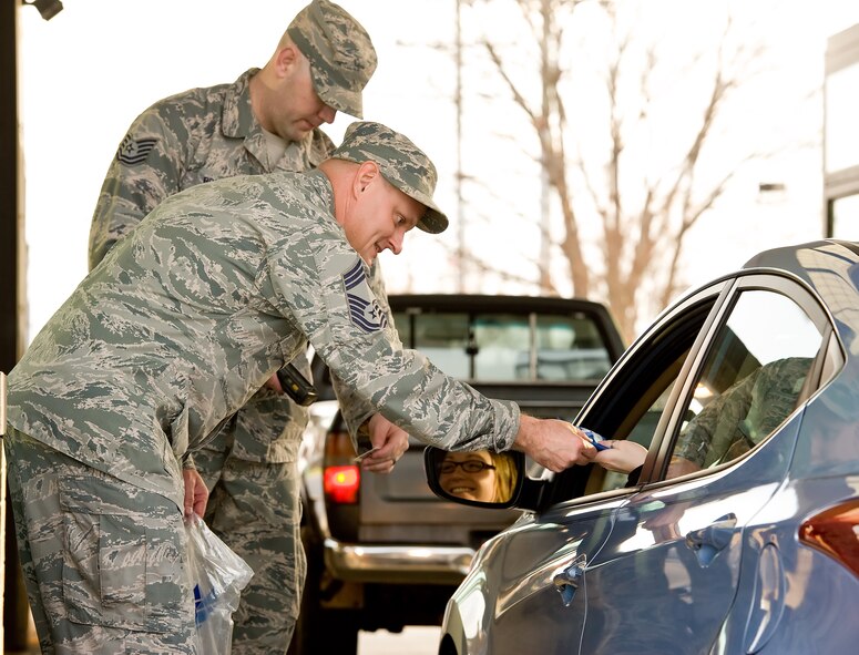 Chief Master Sgt. John Elstrom, 436th Maintenance Group superintendent, hands out a first aid kit to a driver as she enters the base Nov. 25, 2014, at the main gate on Dover Air Force Base, Del. As part of the Wing's Safety Send Off at the main and north gates, Elstrom, the 436th Airlift Wing vice commander and command chief, wing group commanders and their superintendents, and members of the Wing Safety Office, reminded drivers and passengers to be safe over the Thanksgiving Day holiday and wished them a happy holiday. (U.S. Air Force photo by Roland Balik)