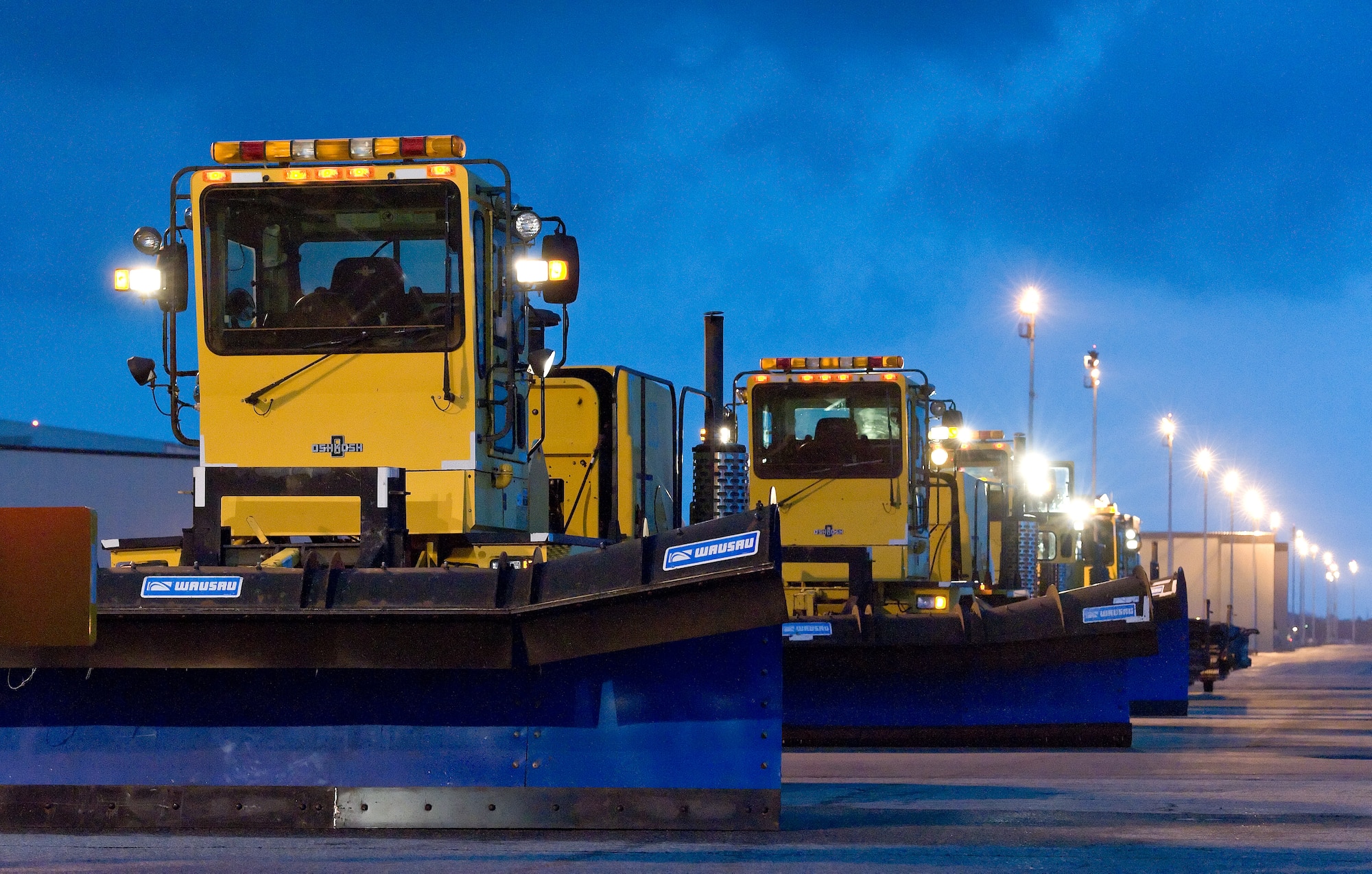 Snow plows belonging to the 436th Civil Engineer Squadron Horizontal Shop sit idle on the flight line after the annual snow parade Nov. 6, 2014, on Dover Air Force Base, Del. Members of the 436th Civil Engineer Squadron Horizontal Shop let wing leadership drive airfield snow plow, blower and broom type airfield snow removal vehicles down the flight line just before rain hit the base as a cold front passed through. (U.S. Air Force photo by Roland Balik)