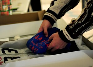 U.S. Air Force 2nd Lt. Zakaria Boston, 45th Intelligence Squadron missions commander, packs a gift at Langley Air Force Base, Va., Dec. 2, 2014. The volunteers did not charge, and accepted donations which will be used for morale events within their units. (U.S. Air Force photo by Airman 1st Class Areca T. Wilson/ Released)