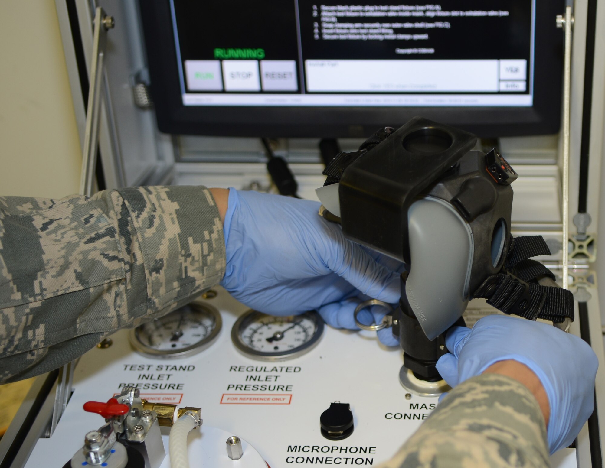 U.S. Air Force Tech Sgt. Phillip Gibbs, 321st Special Tactics Squadron aircrew flight equipment NCO in charge from New York City, places a high-altitude mask on a testing station Nov. 5, 2014, at building 539 on RAF Mildenhall, England. The 321st STS AFE shop maintains more than 70 masks which are disassembled and cleaned every 180 days. (U.S. Air Force photo by Airman 1st Class Dillon Johnston/Released)