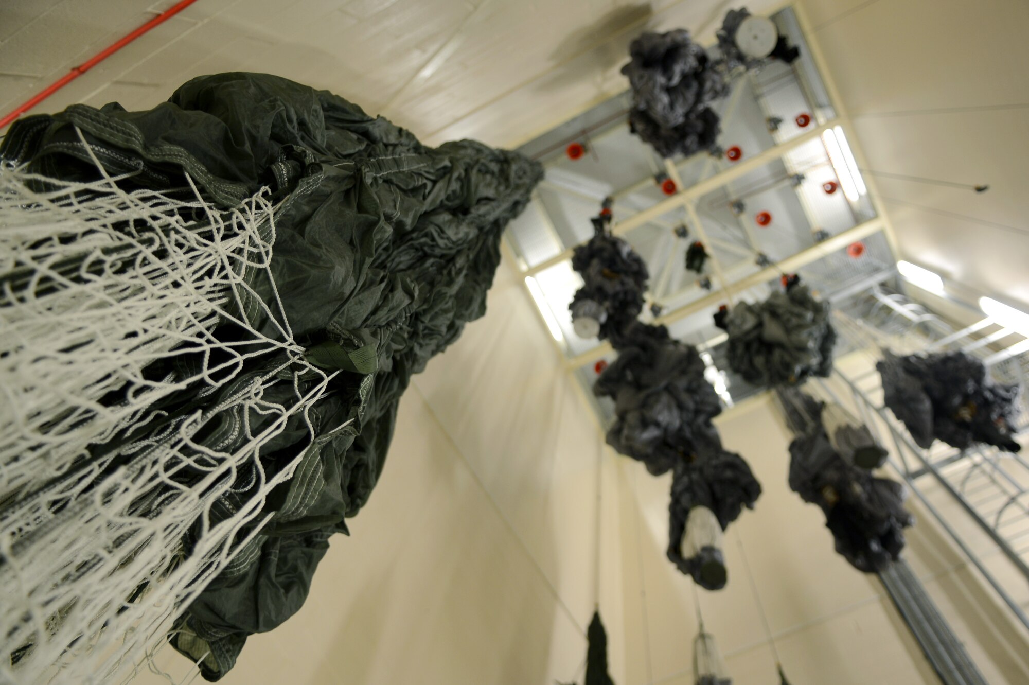 Wet parachutes hang to drip dry after being washed following a water jump Nov. 5, 2014, at building 814 on RAF Mildenhall, England. Each parachute must be cleaned and dried within 24-hours following a jump which would expose them to water, dust or any other contaminates or they are deemed unserviceable. The drying process can take 24 to 48 hours depending on the drying tower used. (U.S. Air Force photo by Airman 1st Class Dillon Johnston/Released)