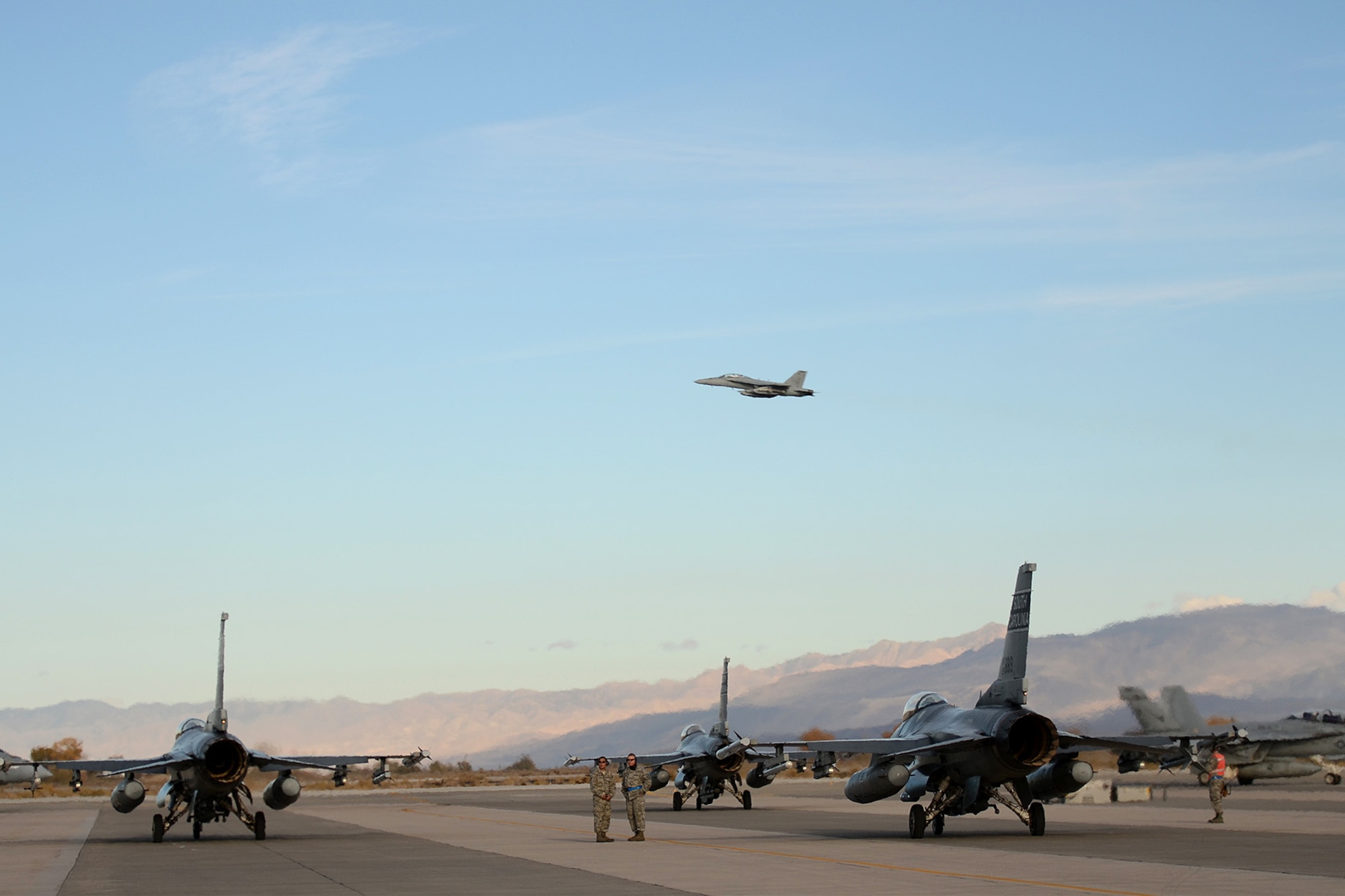 U.S. Air Force fighter pilots from the 157th Fighter Squadron at McEntire Joint National Guard Base, S.C., wait on the flight line to taxi and launch F-16 Fighting Falcon fighter jets for a training mission from Naval Air Station Fallon, Nevada, Nov. 13, 2014. Swamp Fox Airmen from the 169th Fighter Wing and South Carolina Air National Guard are deployed to NAS Fallon to support Naval Carrier Air Wing One with pre-deployment fighter jet training, integrating the F-16’s suppression of enemy air defenses (SEAD) capabilities with U.S. Navy fighter pilots.   (U.S. Air National Guard photo by Tech. Sgt. Caycee Watson/RELEASED)