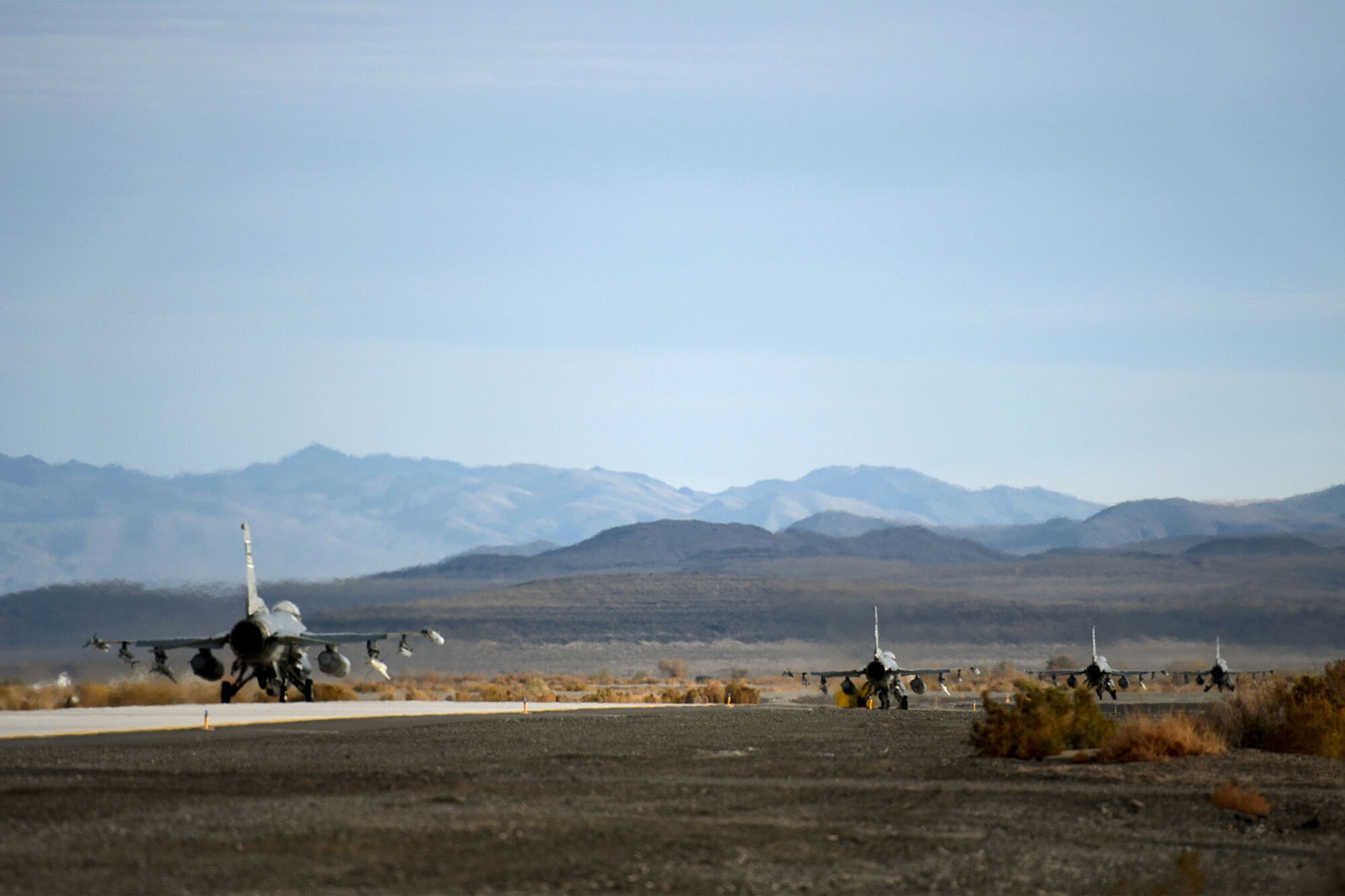 U.S. Air Force fighter pilots from the 157th Fighter Squadron at McEntire Joint National Guard Base, S.C., taxi F-16 Fighting Falcons to take off for a training mission from Naval Air Station Fallon, Nevada, Nov. 12, 2014.  Swamp Fox Airmen from the 169th Fighter Wing and South Carolina Air National Guard are deployed to NAS Fallon to support Naval Carrier Air Wing One with pre-deployment fighter jet training, integrating the F-16’s suppression of enemy air defenses (SEAD) capabilities with U.S. Navy fighter pilots.   (U.S. Air National Guard photo by Tech. Sgt. Caycee Watson/RELEASED)