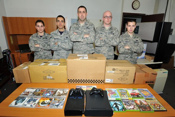 U.S. Air Force Tech. Sgt. Clayton Holcomb, 35th Communications Squadron NCO in charge of infrastructure (center), stands next to Airmen who contributed to Operation Game Drop at Misawa Air Base, Japan, Nov. 21, 2014. Clayton created OGD to collect games and consoles, new or refurbished, for hospitalized children this holiday season. The boxes of video games and systems were mailed to the pediatric ward at the Naval Medical Center Portsmouth in Portsmouth, Virginia and the Shepherd's Rest Women's and Children's Shelter in Dallas, Georgia (U.S. Air Force photo illustration by Senior Airman Jose L. Hernandez-Domitilo)
