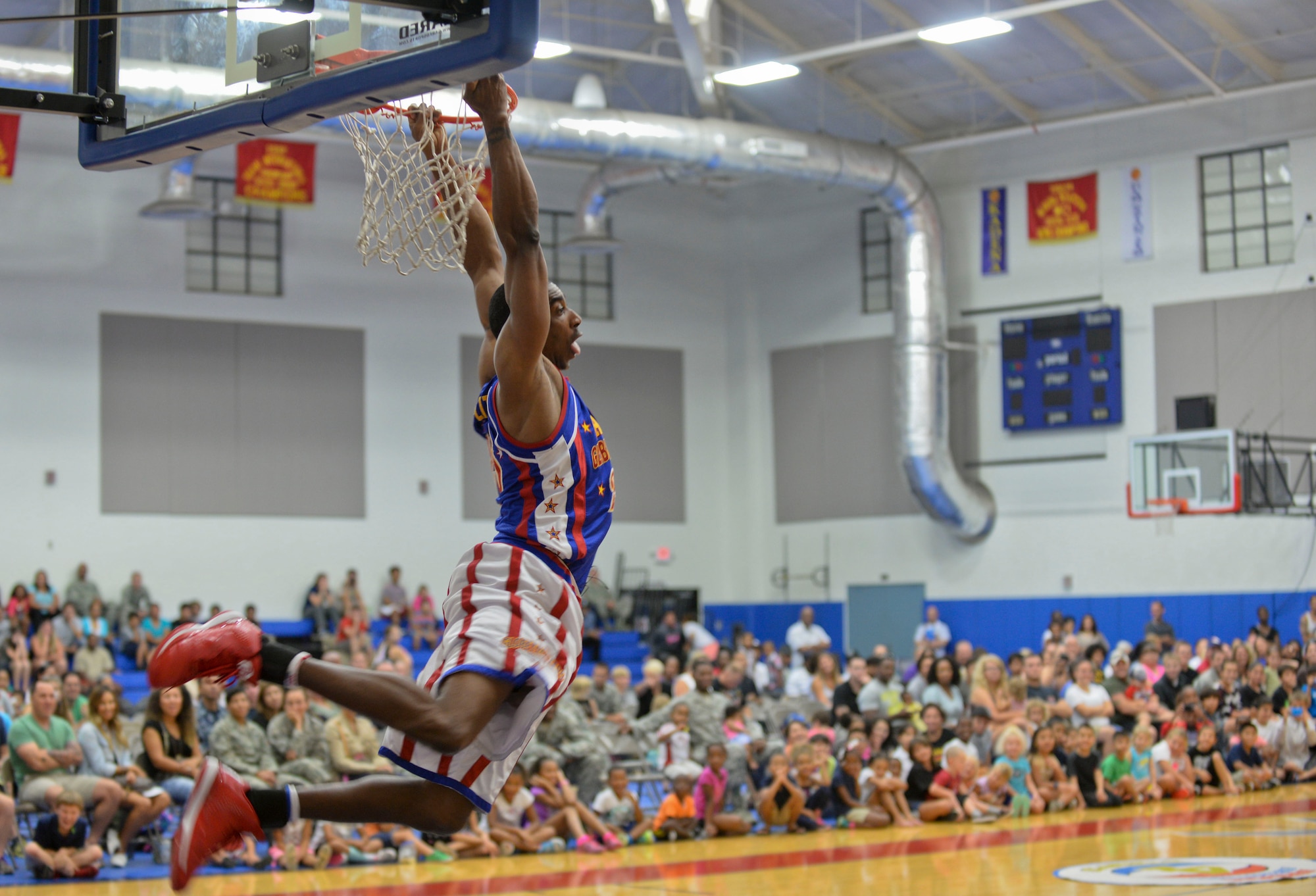Hi-Lite, from The Harlem Globetrotters, dunks during an exhibition basketball game against the Washington Generals, Dec. 1, 2014, at Andersen Air Force Base, Guam. The Globetrotters captivated Team Andersen with their athleticism, theater and comedy as well as its audience participation, choreography, tricks and their overall basketball skill. (U.S. Air Force photo by Staff Sgt. Robert Hicks/Released)  