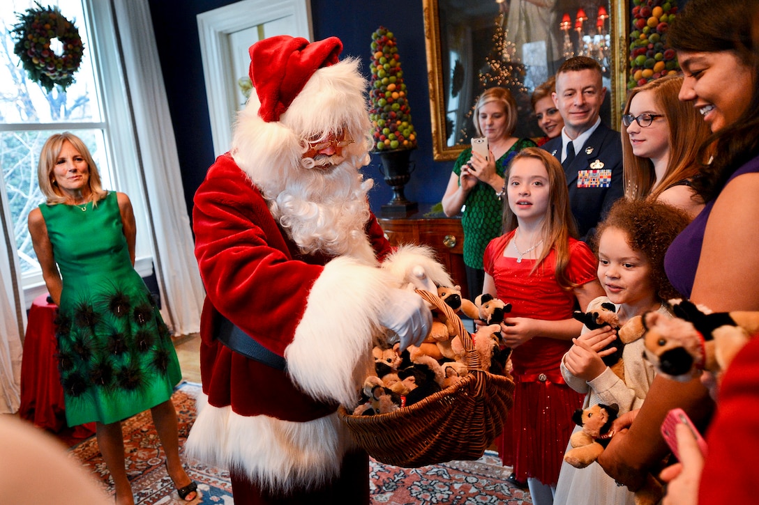 Dr. Jill Biden, far left, wife of Vice President Joe Biden, watches as Santa passes out gifts to military children during a holiday reception she hosted to honor service members, veterans and their families at the vice president’s residence in Washington, D.C., Dec. 3, 2014. 