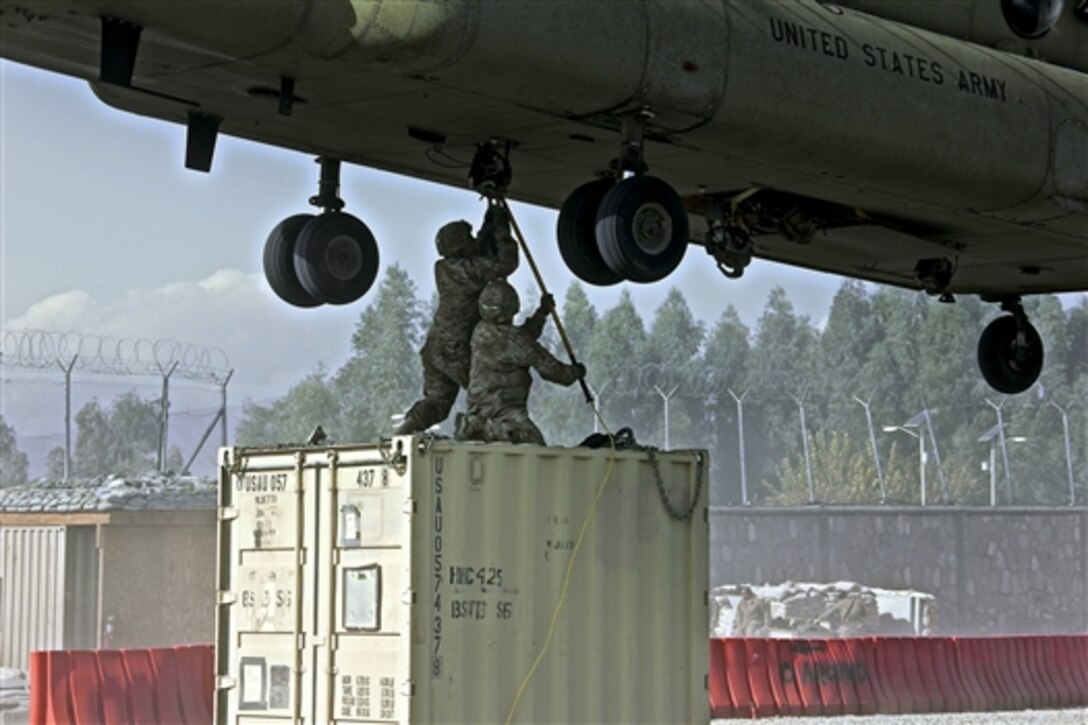 U.S. soldiers attach cargo to a hovering CH-47 Chinook helicopter on Tactical Base Gamberi in Laghman province, Afghanistan, Dec. 1, 2014.