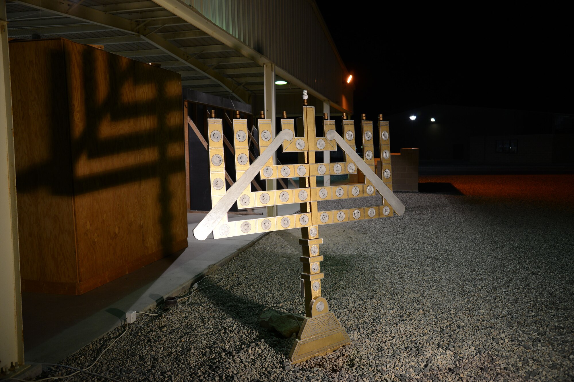 SOUTHWEST ASIA - The Rock's Dec. 3, 2014 holiday lighting ceremony also featured a menorah in addition to a tree. Col. Jason Hanover, 386th Air Expeditionary Wing commander lit the menorah, while Chief Master Sgt. Jan Menard, 386th AEW acting command chief, lit the tree. (U.S. Air Force photo by Tech. Sgt. Jared Marquis)