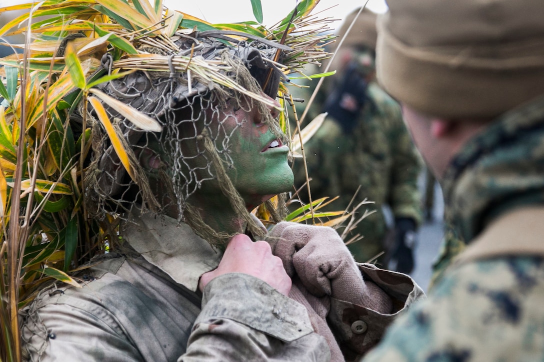 U.S. Marine Lance Cpl. Jonas G. Dewald works with a fellow Marine to don his ghillie suit Dec. 2 in the Oyanohara Training Area in Yamato, Kumamoto prefecture, Japan. The concealment training is part of Forest Light 15-1, a semi-annual, bilateral exercise consisting of a command post exercise and field training events conducted by elements of III Marine Expeditionary Force and the Japan Ground Self-Defense Force to enhance the U.S. and Japan military partnership, solidify regional security agreements and improve individual and unit-level skills. Dewald, from Wilson, North Carolina, is a machine gunner with Weapons Company, 2nd Battalion, 9th Marine Regiment, currently attached to 4th Marine Regiment, 3rd Marine Division, III MEF, under the unit deployment program. 