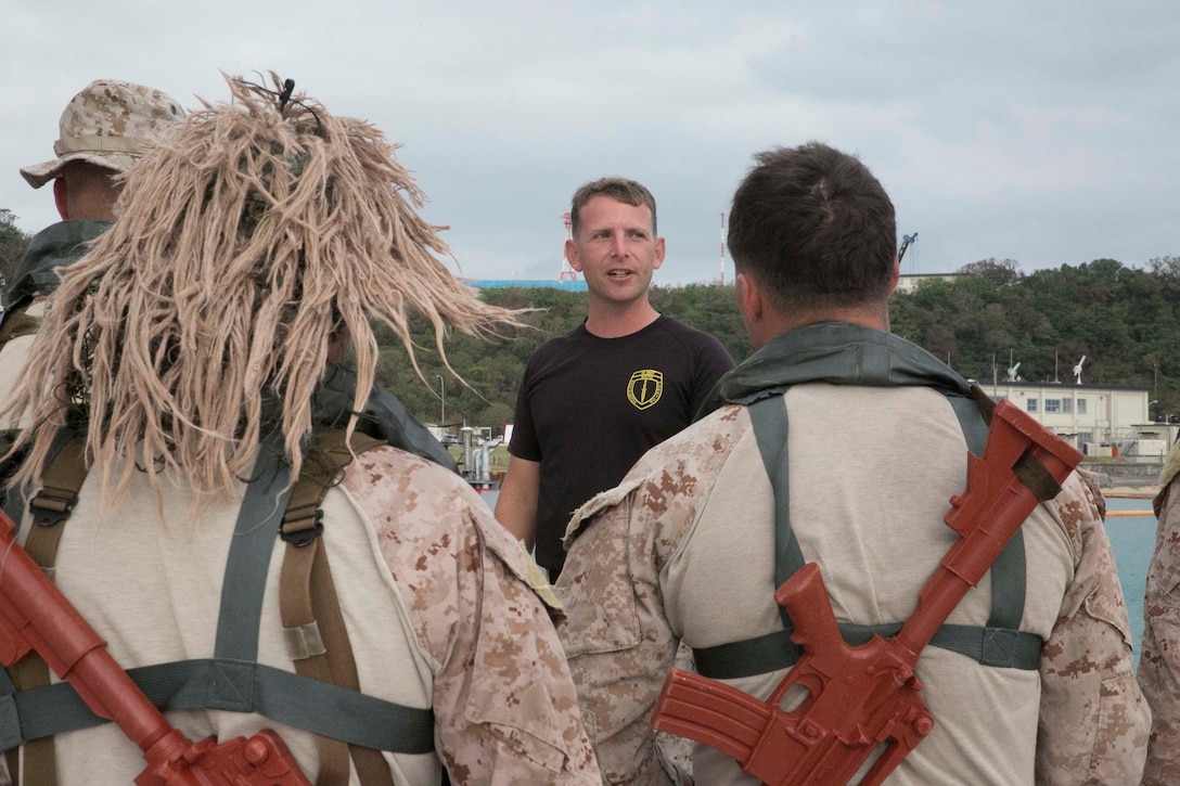 Sgt. Jon C. Walters, left, from Matoaca, Virginia, briefs the Marines over the procedures of engaging urban terrain from the water Oct. 30 at White Beach Naval Facility during the scout swimmers course. The course is 3 weeks long, and progresses the students by taking the skills they learn in the pool and the classroom to the ocean. Walters is the senior amphibious raid instructor with Expeditionary Operations Training Group, III Marine Expeditionary Force Headquarters Group, III MEF. 