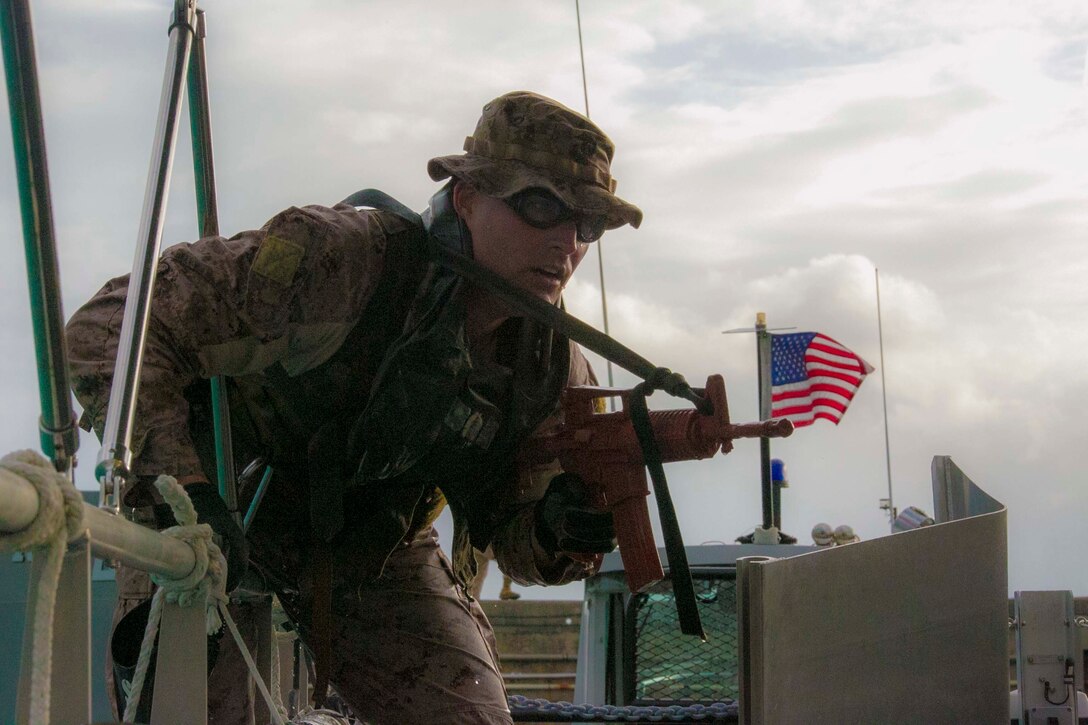 Maj. Breck Perry, from Fredericksburg, Virginia, climbs onto a boat from the water Oct. 30 at White Beach Naval Facility during the scout swimmers course. The students were tasked to stealthily approach urban terrain from the water to exercise insertion techniques. Perry is a student of the course with Expeditionary Operations Training Group, III Marine Expeditionary Force Headquarters Group, III MEF. 