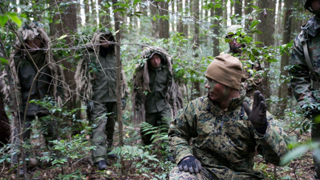 U.S. Marine Sgt. Joseph Armistead, crouching, instructs Japan Ground Self-Defense Force Members during sniper stalk lane training Dec. 2 in the Oyanohara Training Area in Yamato, Kumamoto prefecture, Japan. The training is part of Forest Light 15-1, a semi-annual, bilateral exercise consisting of a command post exercise and field training events conducted by elements of III Marine Expeditionary Force and the JGSDF to enhance the U.S. and Japan military partnership, solidify regional security agreements and improve individual and unit-level skills. Armistead, from Seymour, Tennessee, is a scout sniper with Weapons Company, 2nd Battalion, 9th Marine Regiment, currently attached to 4th Marine Regiment, 3rd Marine Division, III MEF, under the unit deployment program. The JGSDF scout snipers are with 42nd Regiment, 8th Division, Western Army, JGSDF.  (U.S. Marine Corps photo by Cpl. Drew Tech/Released)