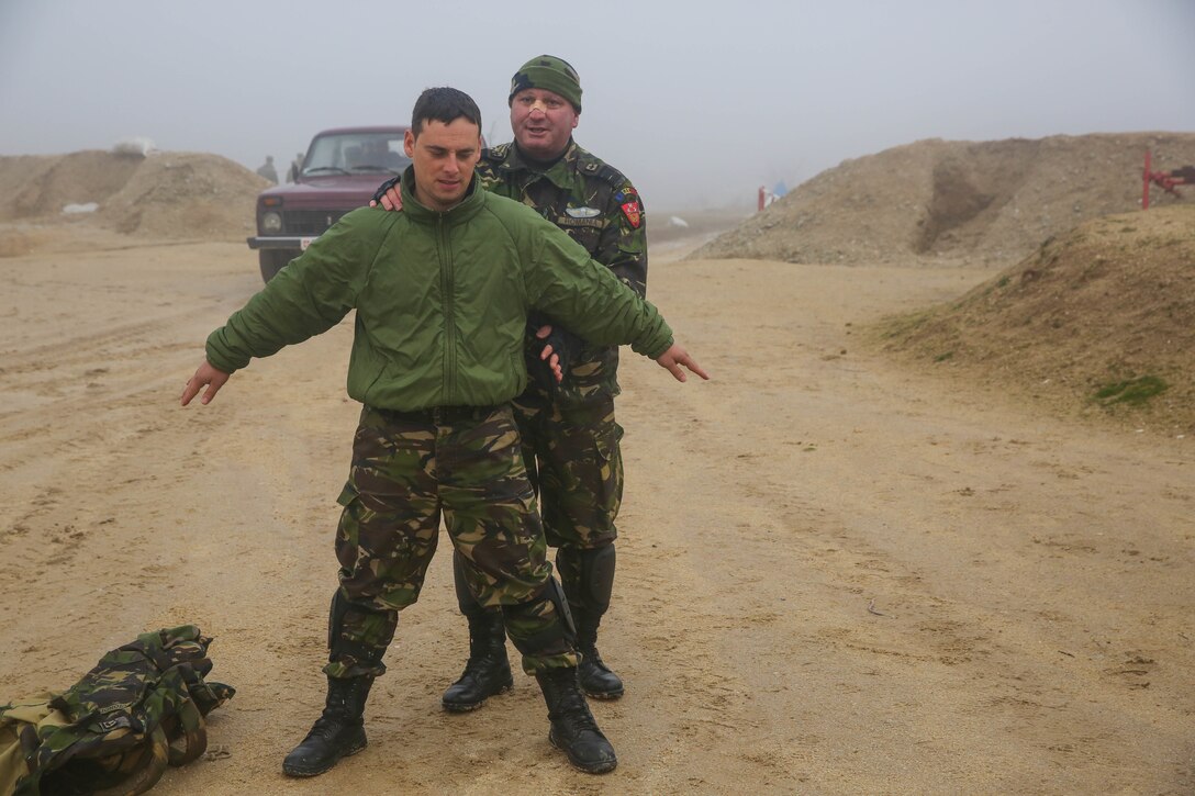 A Romanian soldier instructs an entry control point lesson and performs a search during Exercise Platinum Wolf 15 at South Base, Serbia, Nov. 19. Platinum Wolf is a peacekeeping operations training exercise focused on non-lethal systems and basic infantry skills. Units train together as coalitions, developing and improving proficiency of peacekeeping procedures like crowd and riot control. Forces from Bulgaria, Croatia, Macedonia, Romania, Serbia and the U.S. will be participating in the two week training.
