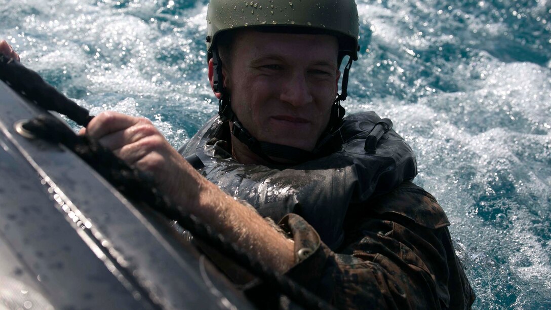 Sgt. Geoffrey P. Mann, from Orlando, Florida, holds on to a combat rubber raiding craft after helocasting to get to an objective Nov. 5 at White Beach Naval Facility during the scout swimmers course. The Marines exercised various amphibious insertion techniques throughout the course. Mann is an intelligence specialist with Expeditionary Operations Training Group, III Marine Expeditionary Force Headquarters Group, III MEF. 