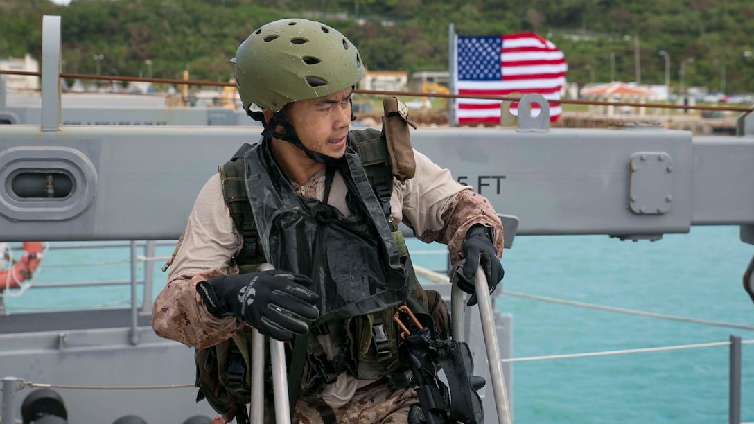 Sgt. Gerry Pratama, from Anahuac, Texas, climbs up the latter after performing the helocasting practical application Nov. 4 during the scout swimmers course at White Beach Naval Facility. Marines rehearsed the procedures they will be doing on the aircraft on pier beforehand hand to ensure readiness. Pratama is a student of the course with Expeditionary Operations Training Group, III Marine Expeditionary Force Headquarters Group, III MEF. 