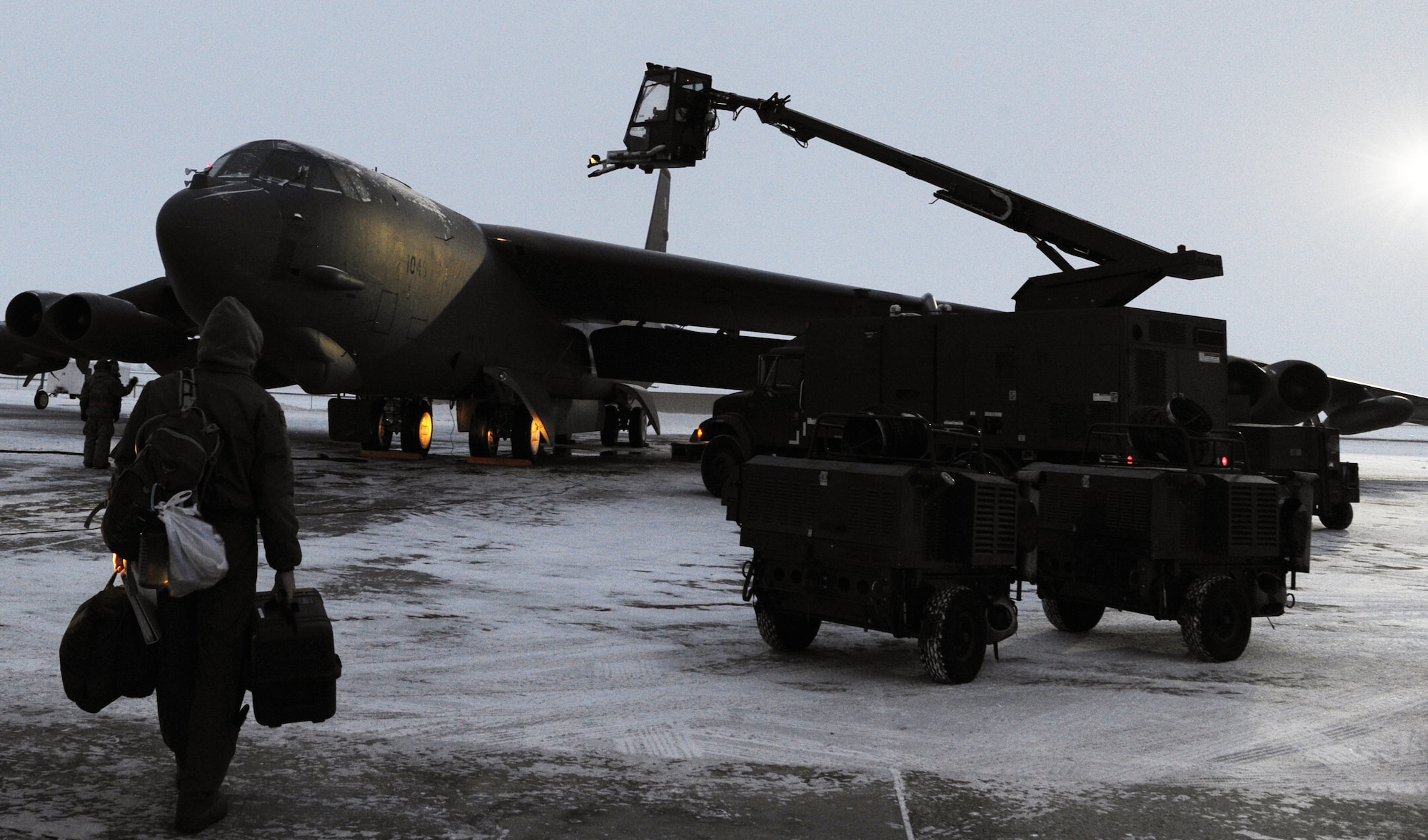 An Aircrew member walks toward a B-52H Stratofortress while it’s being deiced on Minot Air Force Base, N.D. Battling harsh winds and temperatures 20 degrees and below for several days, operations and maintenance Airmen joined together to successfully fly 40 out of 40 sorties during Prairie Warrior surge week. (U.S. Air Force photo/Senior Airman Brittany Y. Bateman)