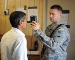 Sgt. Mark Benson, a force protection noncommissioned officer at entry control point 13 with A Troop, 1st Squadron, 82nd Cavalry Regiment, 41st Infantry Brigade Combat Team of the Oregon National Guard scans the eyes of a local national before allowing him to enter Victory Base Complex, Iraq, March 8, 2010.