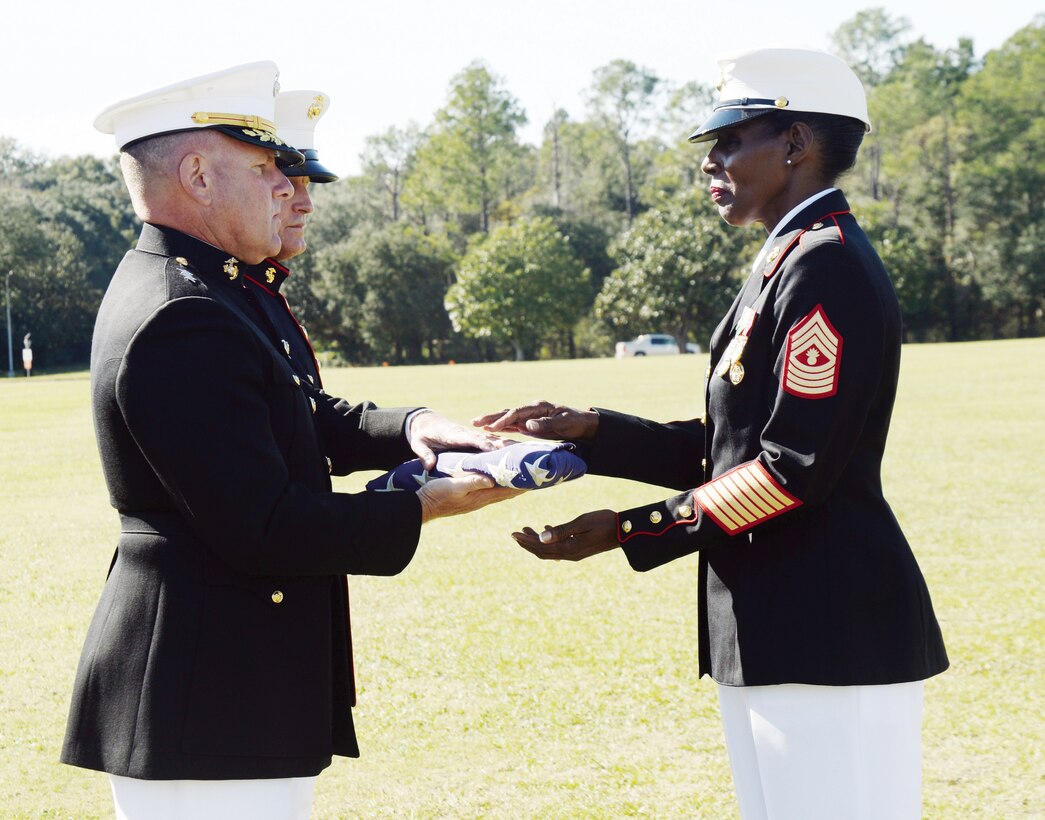 Master Gunnery Sgt. Carlotta Moore receives an American flag from her retiring officer, LOGCOM's commanding general, Maj. Gen. John J. Broadmeadow. The American flag was flown in Afghanistan and presented to Moore during her recent retirement ceremony on Marine Corps Logistics Base Albany's Schmid Field for her honorable and faithful service to the country and the Marine Corps.