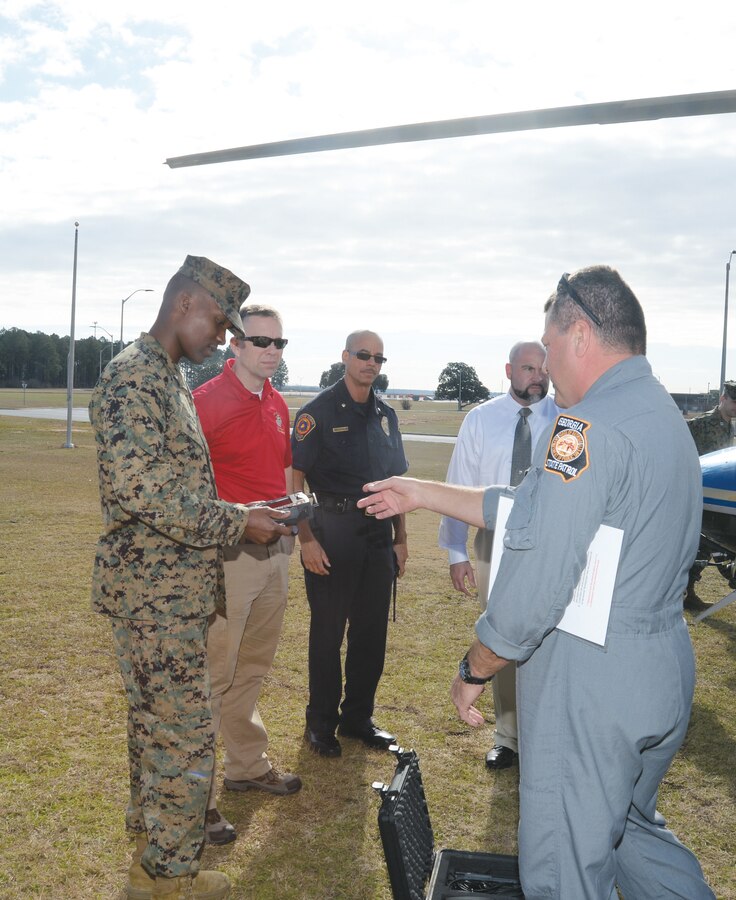 Marine Corps Logistics Base officials inspect a piece of equipment during a pre-training exercise with Georgia State Patrol Aviation pilot, Wayne Wiley, recently. The equipment will allow emergency management staff to monitor ground activity downloaded by GSP AD pilots in the event of an on-base incident.