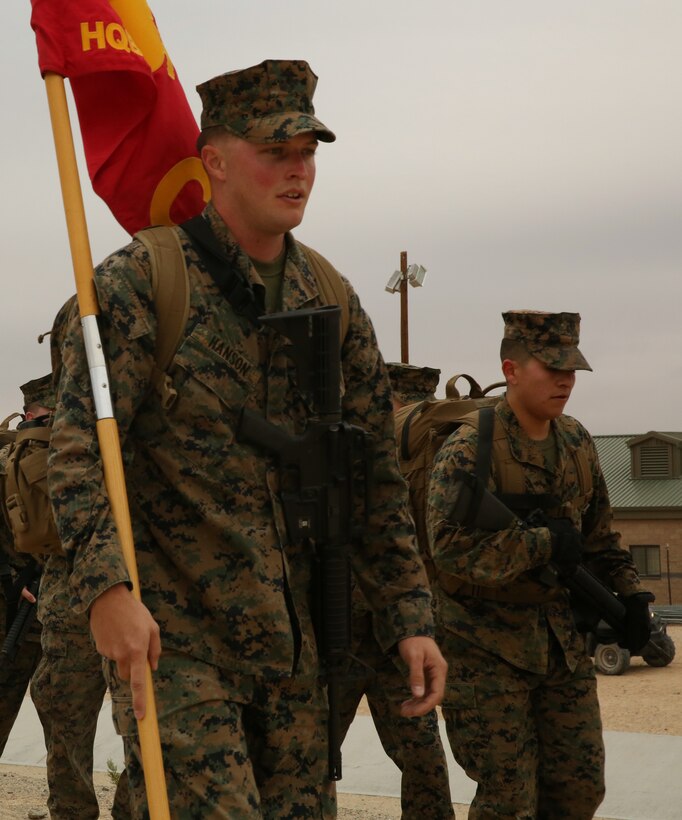 Cpl. Tyler Hanson, logistics chief, Exercise Support Division, Headquarters Battalion, carries the Company C’s guidon during a Non-Commissioned Officers hike led by Sgt. Maj. Abel Leal, battalion sergeant major, aboard the Combat Center, Dec. 3, 2014. (Official Marine Corps photo by Lance Cpl. Thomas Mudd/Released)