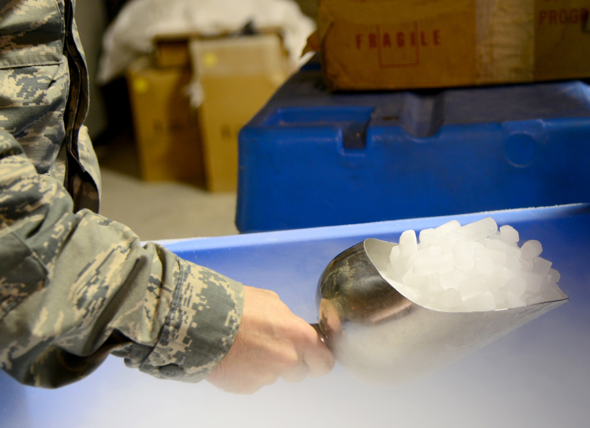 U.S. Air Force Staff Sgt. Chayce Trotter, 379th Expeditionary Medical Group noncommissioned officer in charge of the Blood Transshipment Center, scoops dry ice for packaging blood products, Dec. 4, 2014, at Al Udeid Air Base, Qatar. Not only does the BTC here supply needed blood products throughout U.S. Central Command’s Area of Responsibility, they are also the largest supplier of dry ice in the AOR. (U.S. Air Force photo by Senior Airman Kia Atkins)