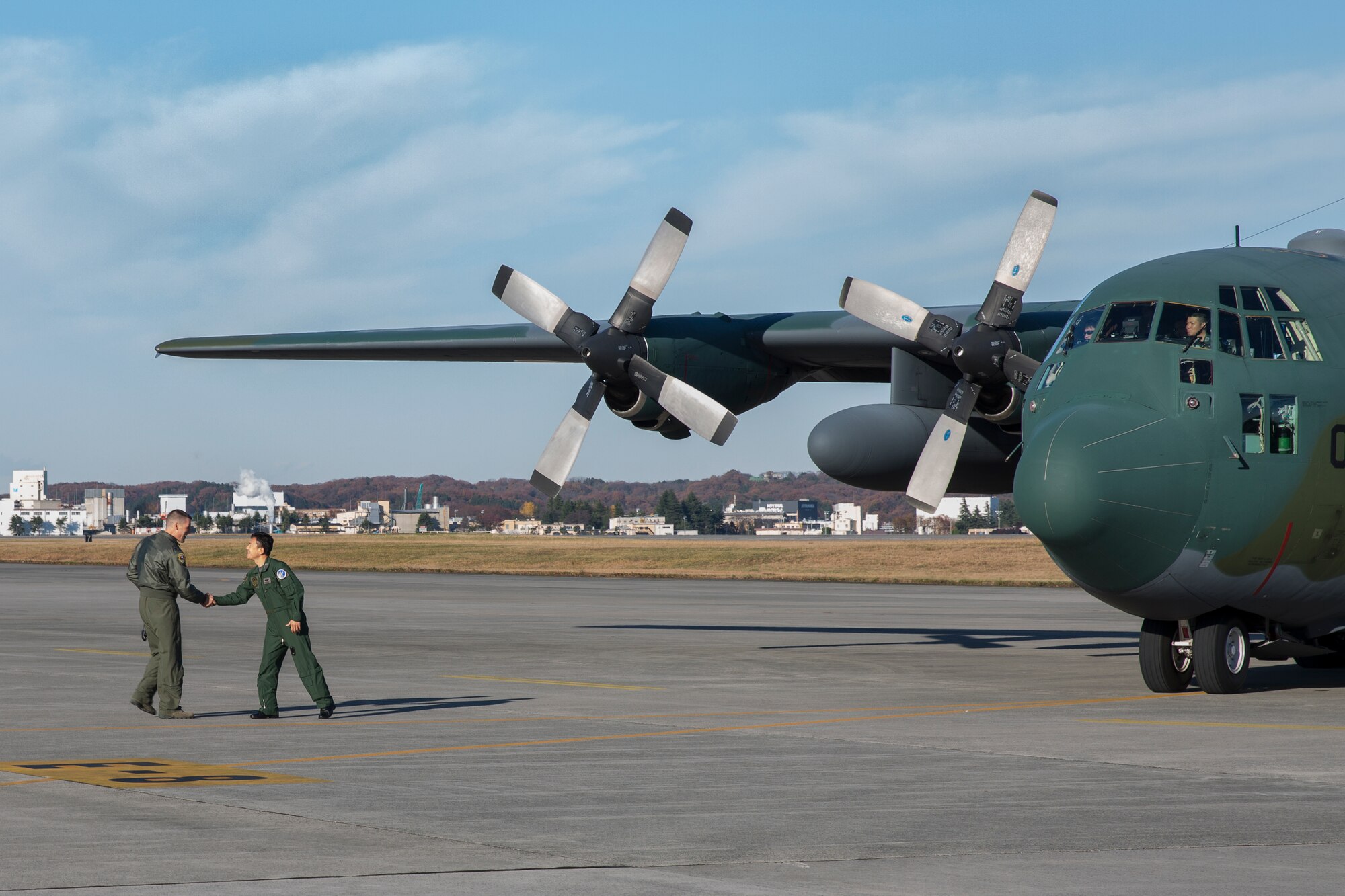 Right to left) Japan Air Self-Defense Force Lt. Col. Hitoshi Uchiyama, 401st Squadron commander, Komaki Air Base and U.S. Air Force Lt. Col. Andrew Campbell, 36th Airlift Squadron commander, greet at Yokota Air Base, Japan, Dec. 3, 2014. JASDF members from the 401st Squadron delivered Operation Christmas Drop donations as part of 40 tons of humanitarian aid headed to various austere locations throughout the Pacific. (U.S. Air Force photo by Osakabe Yasuo/Released)
