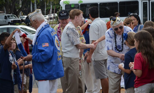 Hickam Elementary School students greet survivors of the Dec. 7, 1941, attack on Pearl Harbor and Hickam Airfield at Joint Base Pearl Harbor-Hickam, Hawaii, Dec. 4, 2014. The survivors visited the school to commemorate the anniversary of the attack and to share their stories with students and faculty. (U.S. Air Force photo by Staff Sgt. Alexander Martinez/Released)