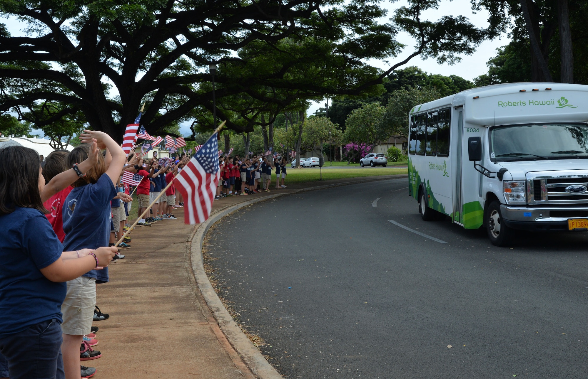 Hickam Elementary School students wave American Flags and cheer for survivors of the Dec. 7, 1941, attack on Pearl Harbor and Hickam Airfield at Joint Base Pearl Harbor-Hickam, Hawaii, Dec. 4, 2014. The survivors visited the school to commemorate the anniversary of the attack and to share their stories with students and faculty. (U.S. Air Force photo by Staff Sgt. Alexander Martinez/Released)