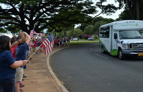 Hickam Elementary School students wave American Flags and cheer for survivors of the Dec. 7, 1941, attack on Pearl Harbor and Hickam Airfield at Joint Base Pearl Harbor-Hickam, Hawaii, Dec. 4, 2014. The survivors visited the school to commemorate the anniversary of the attack and to share their stories with students and faculty. (U.S. Air Force photo by Staff Sgt. Alexander Martinez/Released)