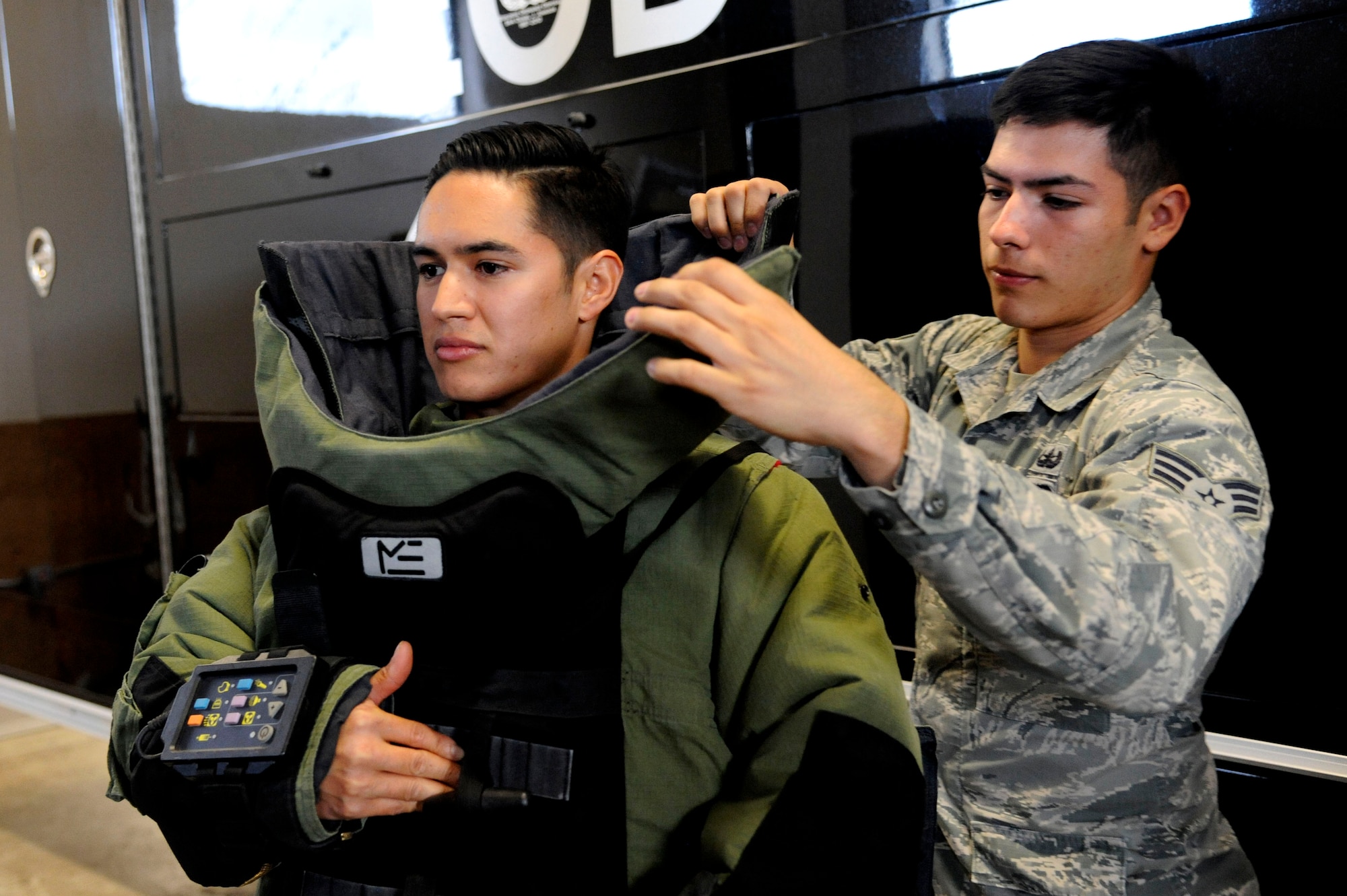 Staff Sgt. James Ruiz, 30th Civil Engineer Squadron explosive ordnance disposal specialist, receives assistance donning his EOD 9 bomb suit Dec. 3, 2014, Vandenberg Air Force Base, Calif. The EOD 9 bomb suit is designed to withstand the pressure released from an explosive device and shrapnel produced. (U.S. Air Force photo by Staff Sgt. Jim Araos/Released)