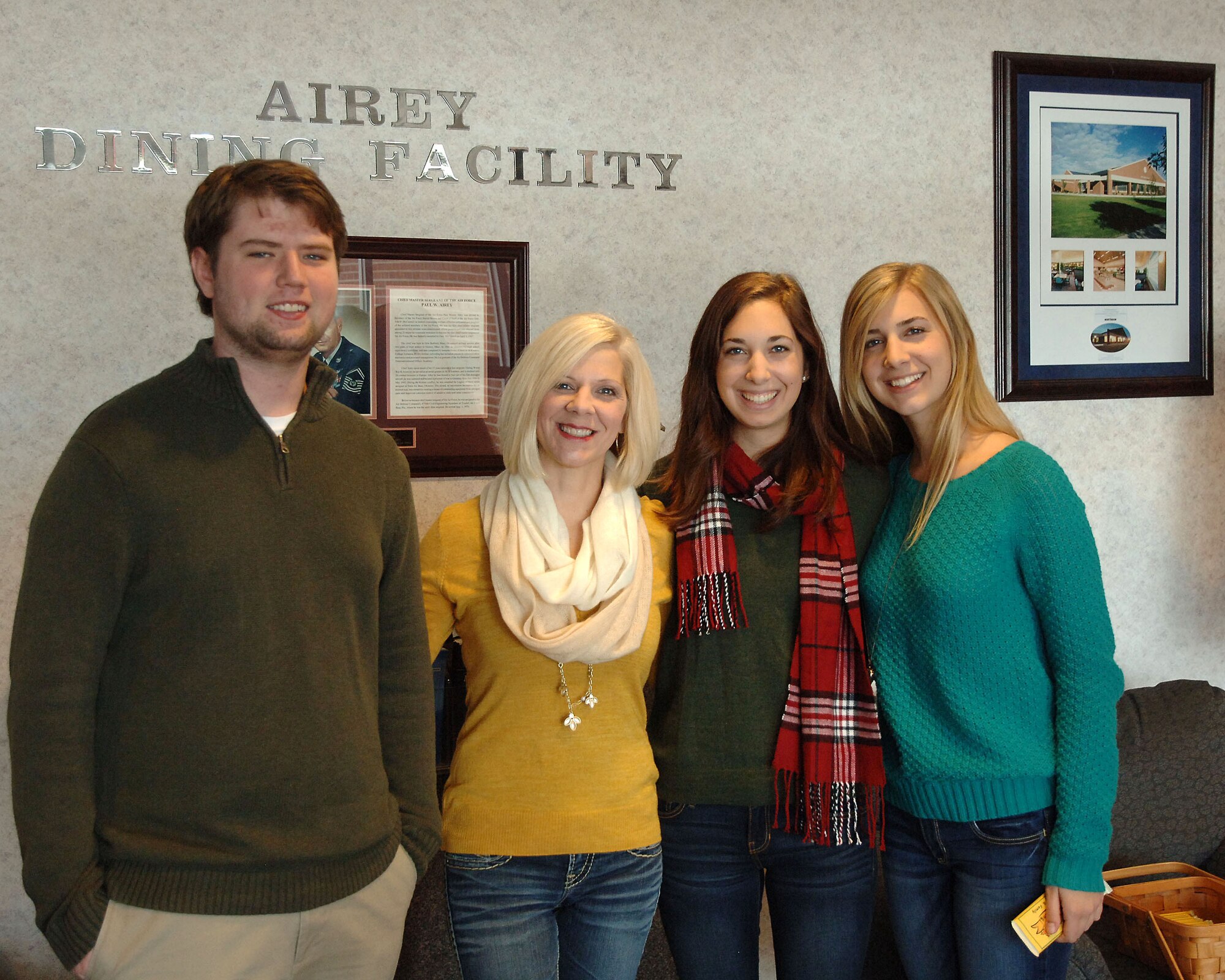Eli Duncan, son of Chief Master Sgt. David Duncan, 319th Air Base Wing command chief master sergeant and Bonnie Bauman, wife of Col. Paul Bauman, 319th Air Base Wing commander,  and their daughters pose for a photo on Thanksgiving at the Airey Dinning Facility on Grand Forks Air Force Base, N.D. on Nov. 27, 2014. Airmen were given a Thanksgiving candy bar to boost morale and to thank Airmen for what they do. (U.S. Air Force photo/2nd Lt. James Fisher)