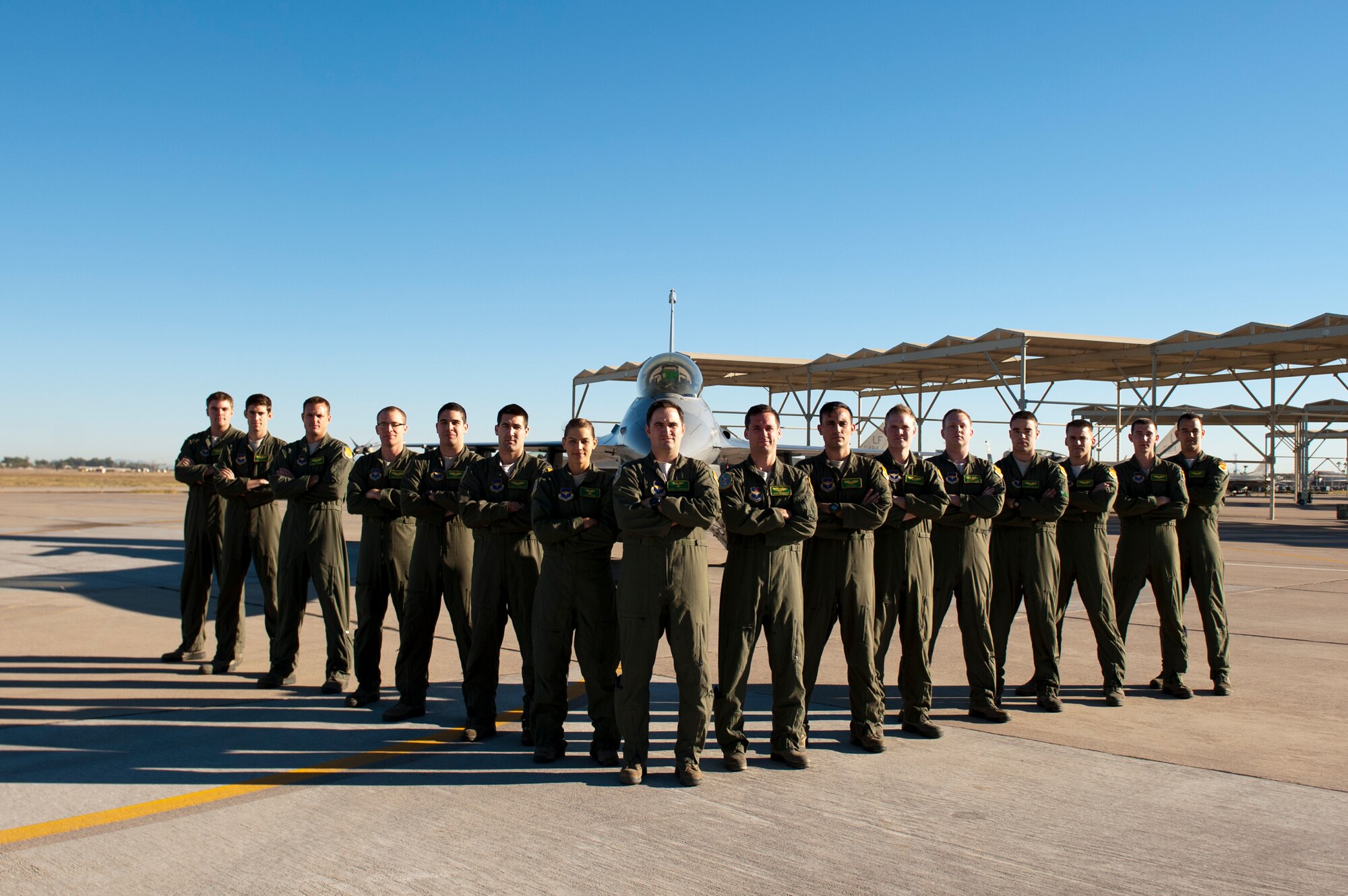 The 310th Fighter Squadron graduated 15 F-16 Fighting Falcon pilots in Class 14-CBG. They are, from left, 1st Lt. Daniel Brom, Capt. Ben Saunders, 1st Lts. Michael Sturgis, Mike Dreher, Luis Monsalve, Derek Hagemeier and Zoe Kotnik; Maj. Barry Crawford; 1st Lts. James Van Decar, Don Patrick Roney, Payton Jeppesen, Garrett Bain, Jeremy Devlin, Scott Eldredge (on medical hold), Kyle Benham and Jacob Kerford. (U.S. Air Force photo/Staff Sgt. Staci Miller)