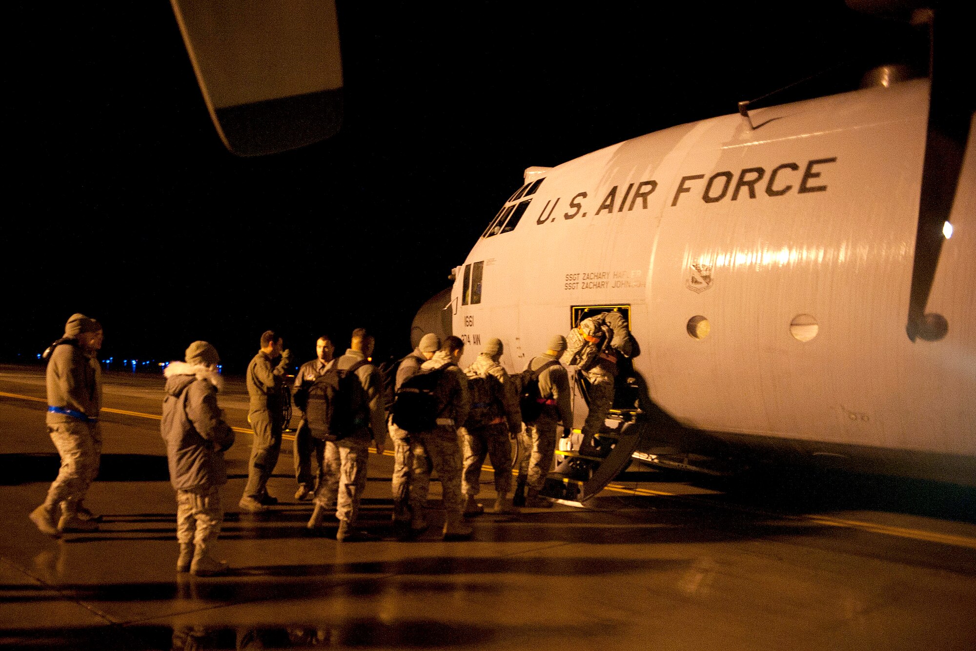 Airmen board a C-130 Hercules during exercise Beverly Sunrise 15-1 at Misawa Air Base, Japan, Dec. 3, 2014. These were the first of approximately 200 Airmen who flew to an alternate location to continue exercise operations with other bases in Pacific Air Forces. The C-130 is assigned to Yokota Air Base, Japan. (U.S. Air Force photo by Airman 1st Class Jordyn Rucker/Released)