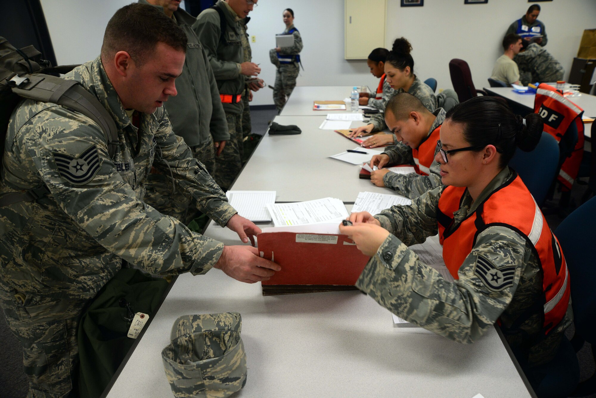 Airmen from the 35th Fighter Wing pass through a Personnel Deployment Function line Dec. 4, 2014, at Misawa Air Base, Japan. The PDF line supported Beverly Sunrise 15-1 which supported the deployment of about 200 Airmen. The exercise was Misawa’s first exercise to be conducted under the Commander’s Inspection Program, which allows commanders to shape their exercises to ultimately help units execute their mission more effectively. (U.S. Air Force photo by Staff Sgt. Derek VanHorn/Released)