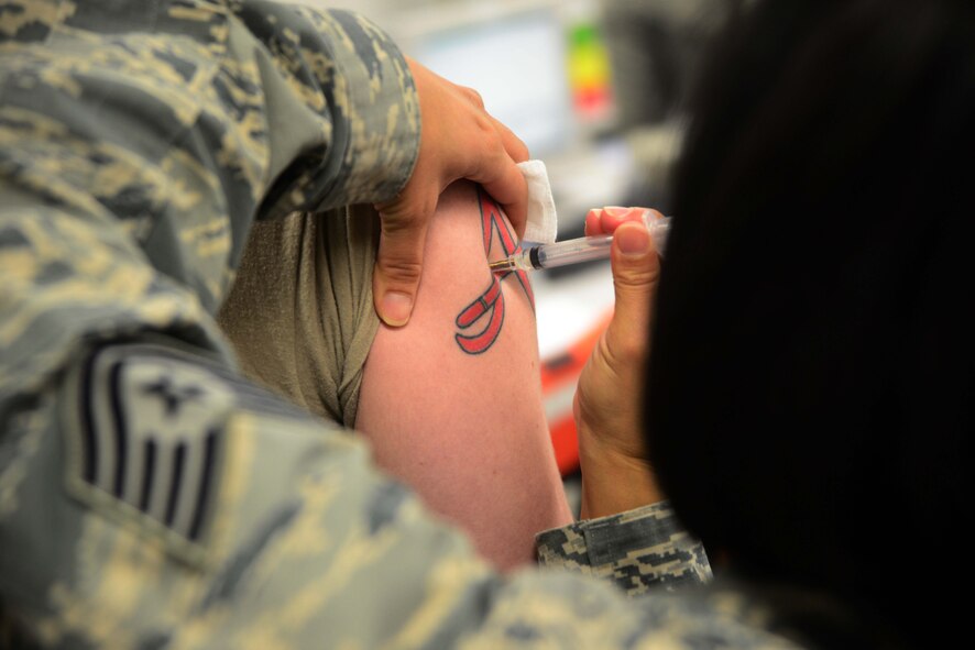 Senior Airman Matthew Gee, 35th Maintenance Squadron aircraft structural maintainer, receives a typhoid immunization Dec. 4, 2014, while passing through a Personnel Deployment Function line at Misawa Air Base, Japan. Representatives from various organizations, including medical, chapel and legal were there to ensure each Airman was properly prepared. (U.S. Air Force photo by Staff Sgt. Derek VanHorn/Released) 