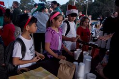 Children wait for a cup of hot chocolate during the Christmas tree lighting ceremony Dec. 3, 2014, at Joint Base Charleston – Air Base, S.C. (U.S. Air Force photo/Senior Airman Jared Trimarchi) 