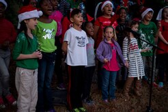Children sing “Jingle Bells” during the Christmas tree lighting ceremony Dec. 3, 2014,  at Joint Base Charleston – Air Base, S.C. Airmen, Sailors, civilians, families and friends gathered around the tree to sing carols, enjoy cookies, drink hot chocolate and to  meet Santa Claus. (U.S. Air Force photo/Senior Airman Jared Trimarchi) 